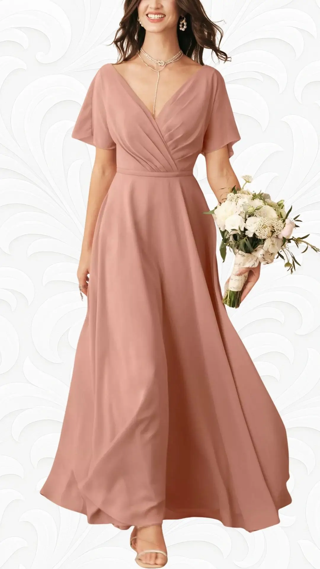 A flowy A-line spring wedding guest dress in a soft dusty rose color features a V-neckline and short flutter sleeves. The dress has a flattering waist with pleating details, complemented by a matching bouquet of white flowers held in one hand. Simple strappy sandals complete the elegant look.