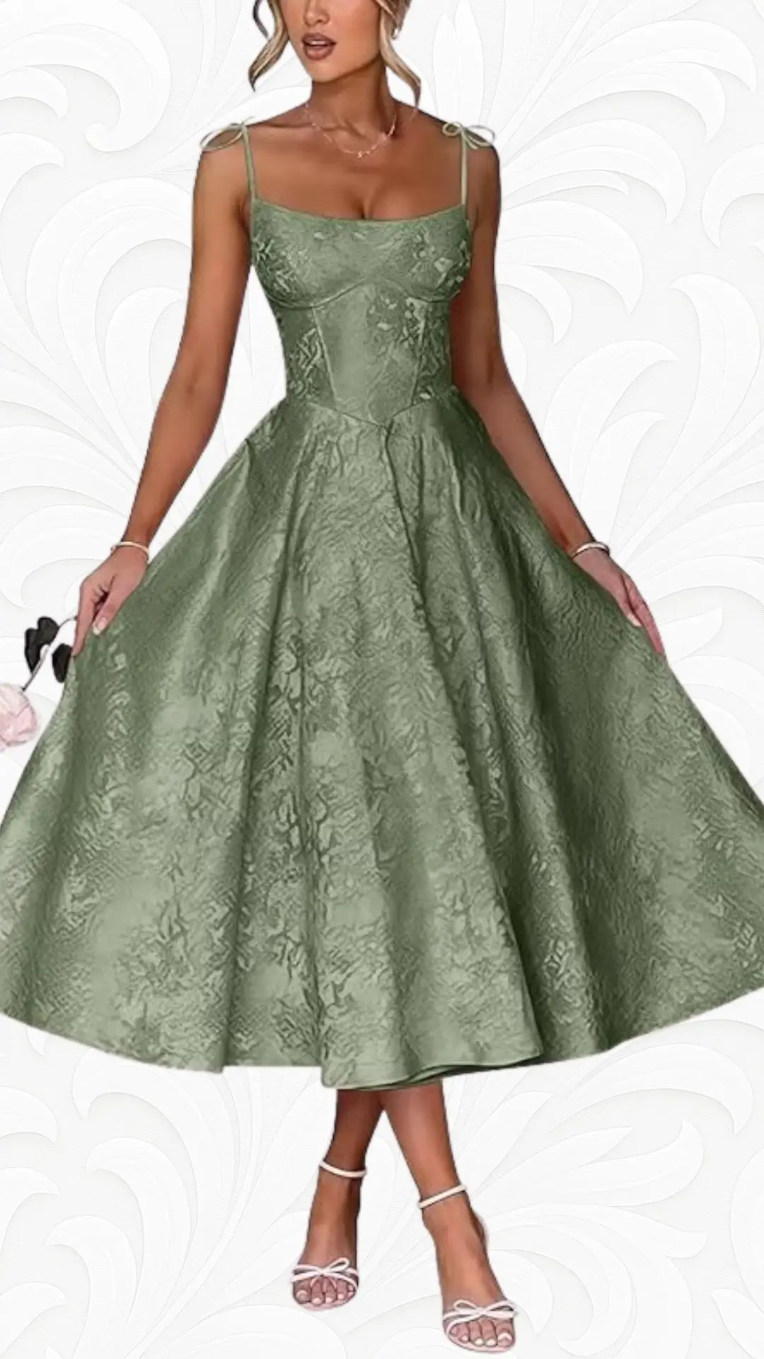 A-line wedding guest dress in a soft green hue features a fitted bodice with delicate adjustable spaghetti straps and a flared knee-length skirt. The fabric showcases an intricate floral texture, enhancing its elegant silhouette. Paired with strappy white heeled sandals, this dress exudes a classic yet modern charm.