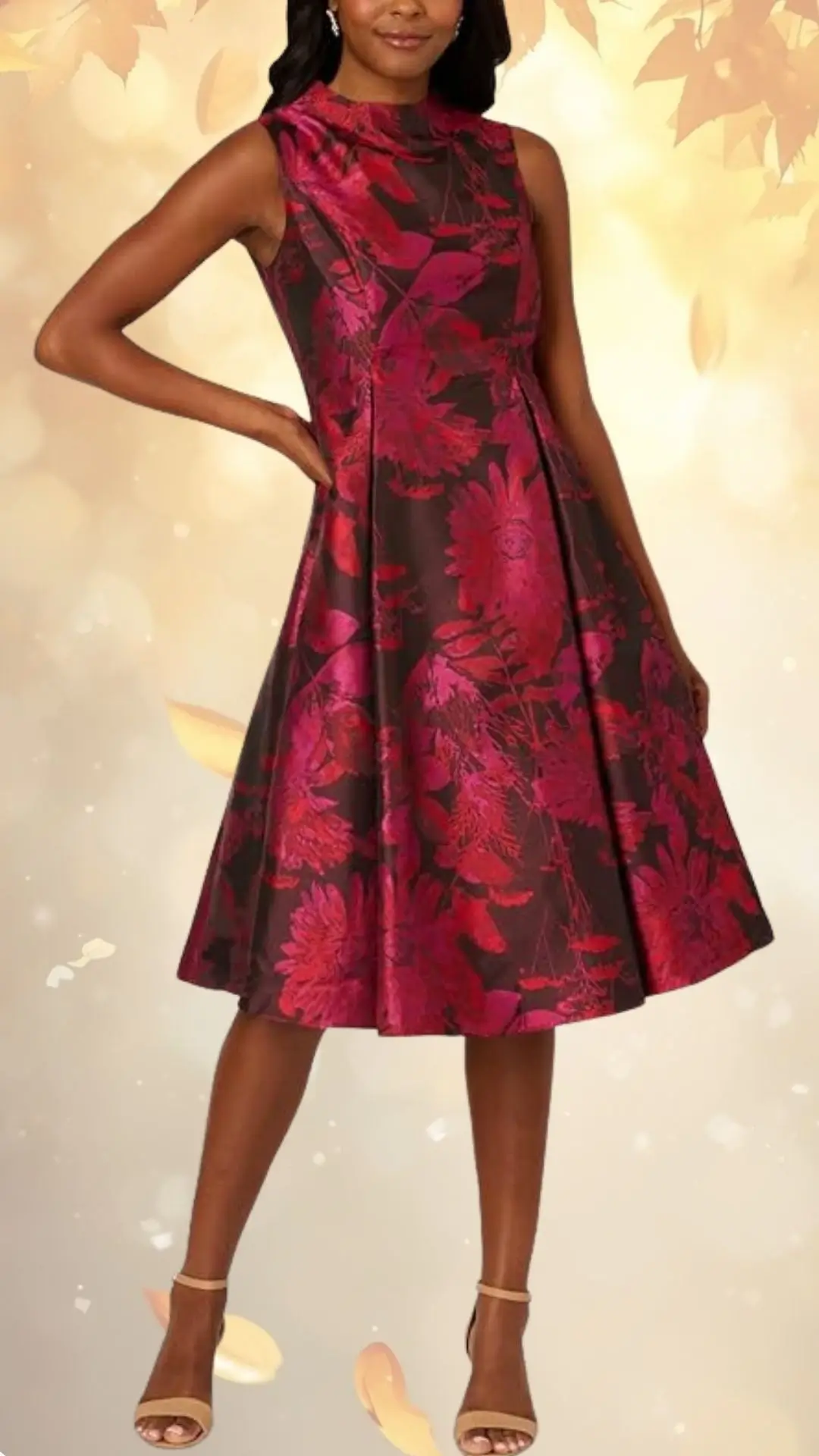 A fall floral wedding guest dress features a fitted bodice and a flared skirt, showcasing a rich burgundy background adorned with vibrant pink floral patterns. The dress has a modest neckline and is paired with strappy nude heels, creating an elegant look suitable for autumn events.