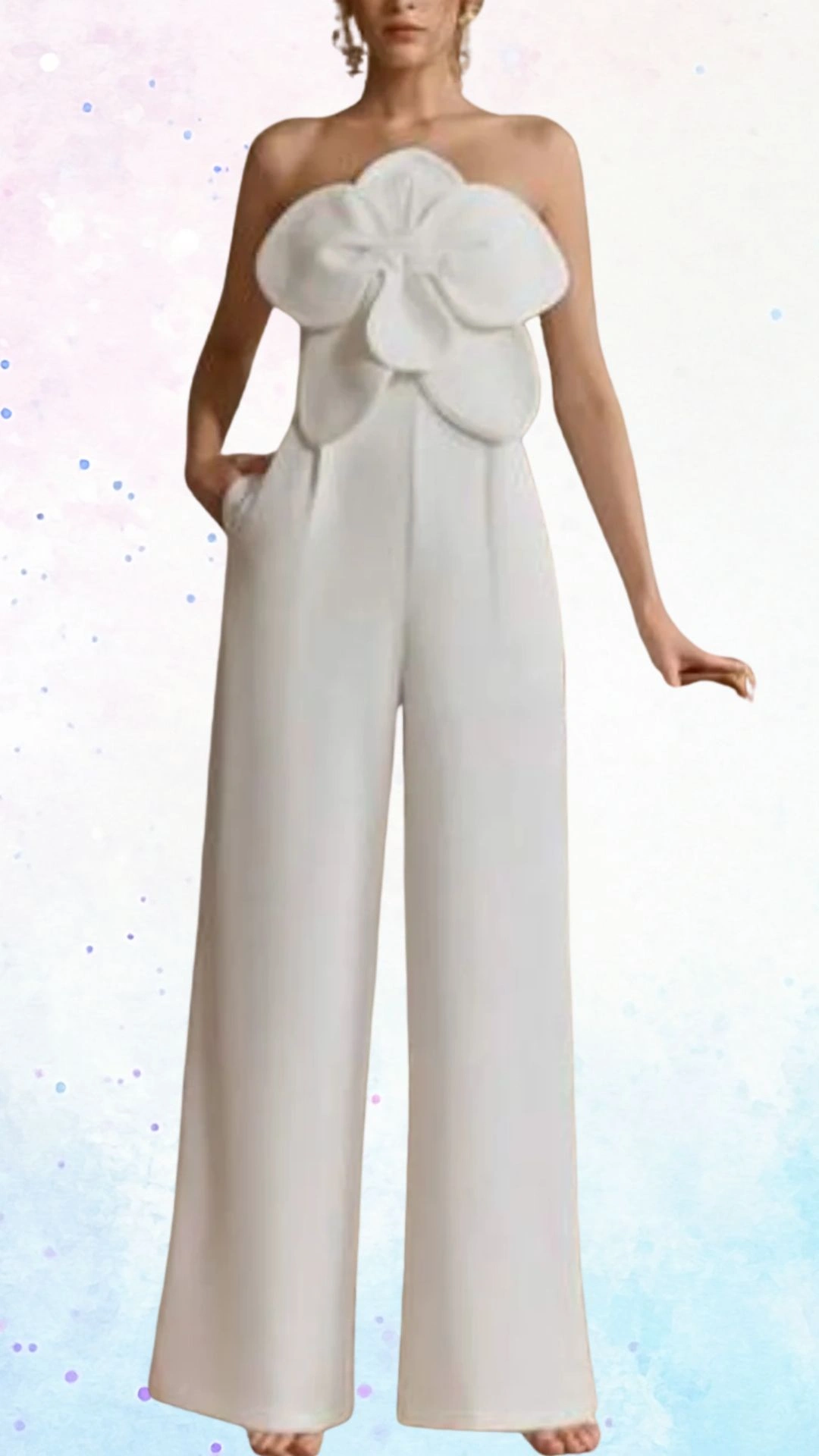 The outfit features a strapless jumpsuit in a soft white fabric, accented by an oversized flower detail at the neckline. Its wide-leg silhouette and flowing material create an elegant and airy feel, perfect for celebrating a baby shower. Hidden pockets and a smooth texture enhance both style and comfort.