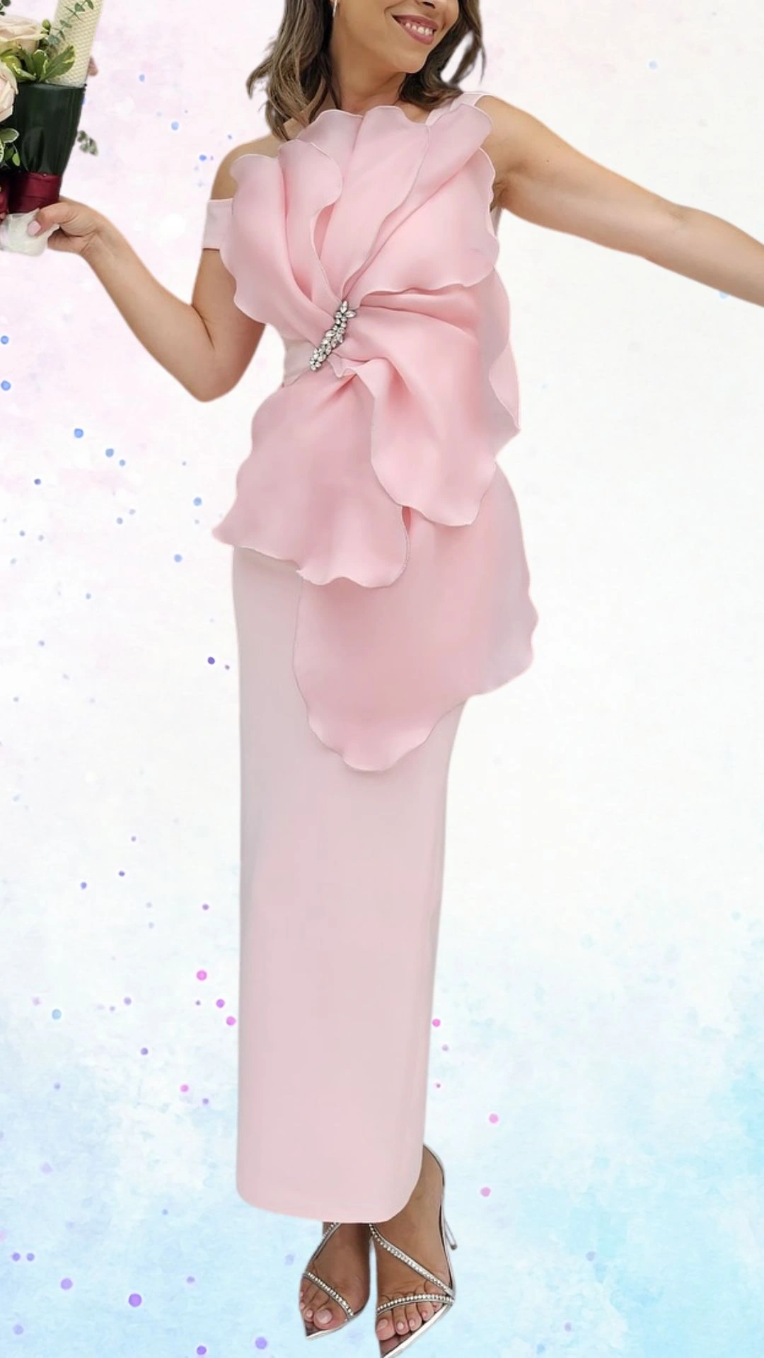 A flowing pink dress features an off-the-shoulder design and a large, delicate floral embellishment at the waist, adorned with sparkling jewels. The fabric is soft and lightweight, enhancing the garment's elegance, while the sleek, fitted skirt falls gracefully to the floor. This ensemble is perfectly suited for celebrating a joyful occasion, embodying a sense of softness and charm.