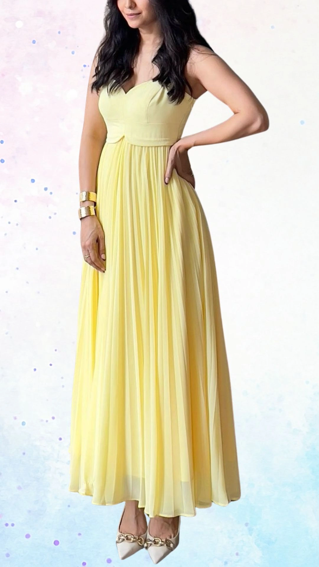 The outfit features a flowing yellow gown with a sweetheart neckline and spaghetti straps, creating an elegant profile suitable for a baby shower. The fabric is lightweight and pleated, adding movement and grace, while the fitted bodice gently flares into a full skirt, enhancing the celebratory feel. Paired with chic pointed-toe heels, this ensemble radiates a joyful and welcoming ambiance.
