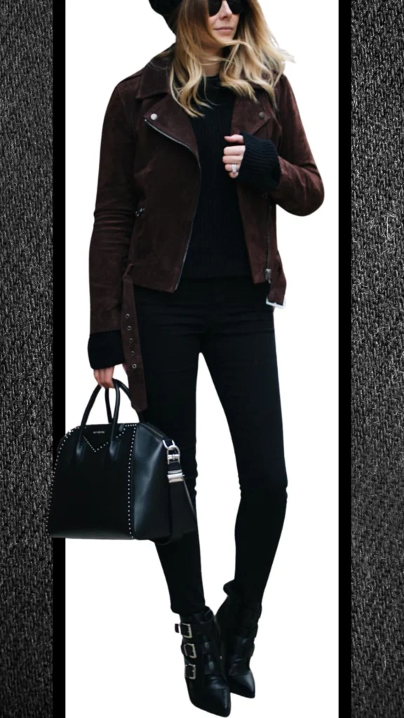 The outfit features a form-fitting pair of black jeans paired with a textured black knit sweater and a rich brown suede biker jacket. Accessorized with a structured black handbag adorned with silver studs and sleek pointed ankle boots with buckle details, this ensemble offers a chic, layered look perfect for winter. The contrasting textures and deep shades enhance its stylish appeal, making it a striking choice for cooler months.