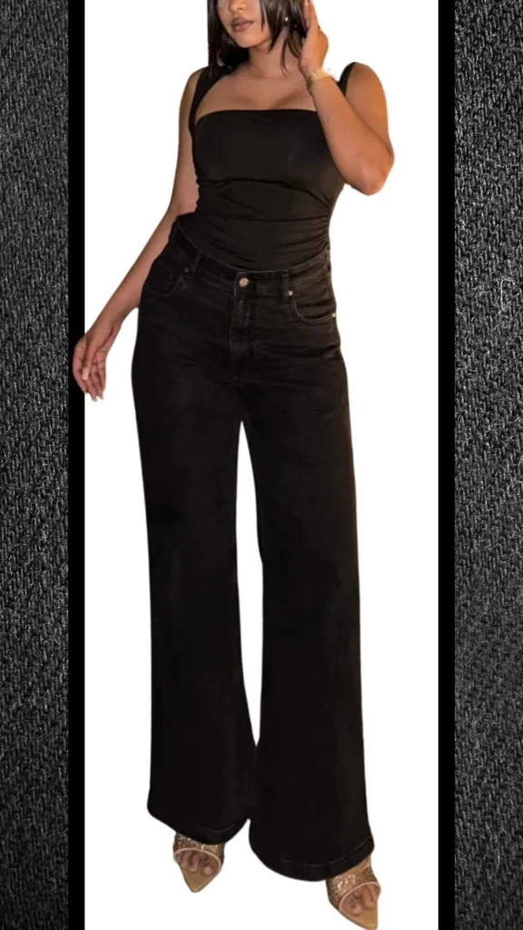 The outfit features high-waisted, wide-leg black jeans crafted from a soft denim, paired with a fitted black sleeveless top that has a smooth, sleek texture. Accessorized with elegant strappy heels, this ensemble combines a modern silhouette with a timeless color palette, making it perfect for winter styling.
