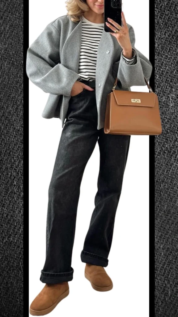 A stylish winter ensemble featuring black high-waisted jeans, paired with a cozy grey oversized jacket and a classic black-and-white striped top. The look is complemented by sleek tan suede slip-on shoes and a structured brown handbag, adding warmth and texture to the outfit while maintaining a modern aesthetic.