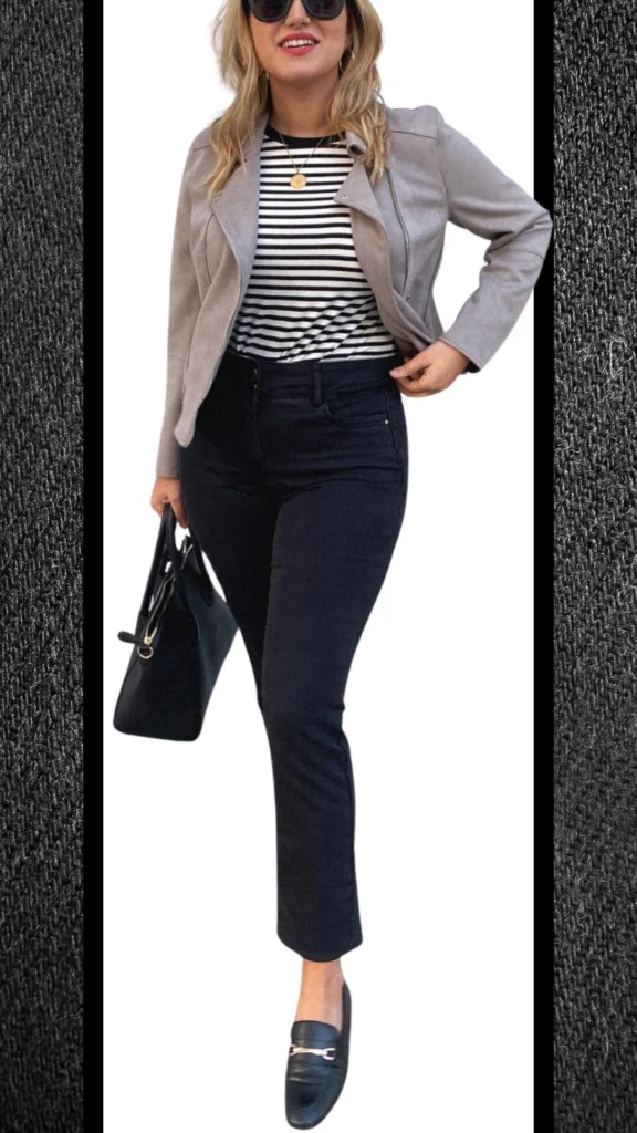 This chic winter outfit features fitted black jeans with a smooth texture, paired with a striped long-sleeve top that adds a classic touch. A stylish light gray moto jacket provides warmth and a modern silhouette, while black loafers and a structured handbag complete the ensemble, enhancing its elegant appeal. The combination of colors and layers makes this outfit perfect for cooler months.