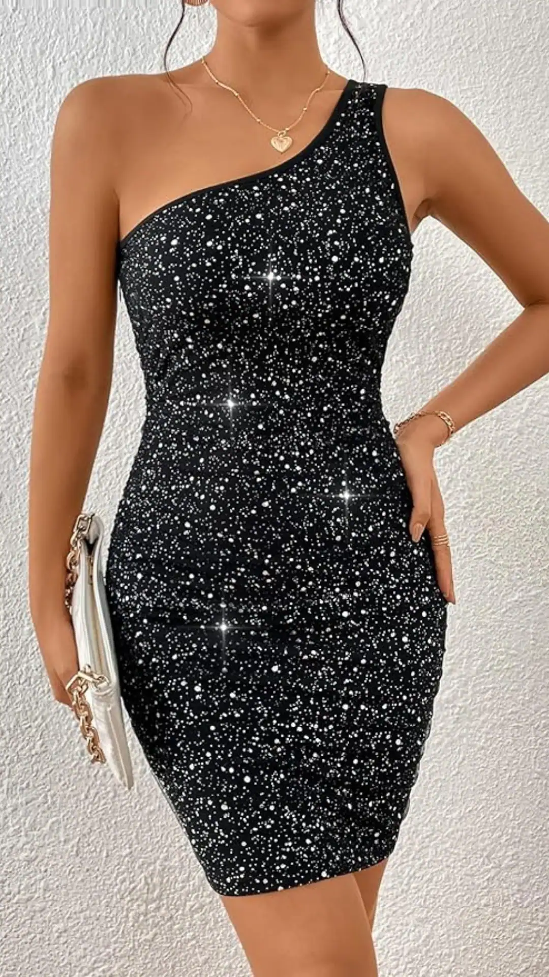 This sleek, one-shoulder black homecoming dress features a shimmering sequin design that reflects light beautifully, adding a glamorous touch. The fitted silhouette hugs the body, creating a chic and trendy vibe, ideal for formal events like homecoming or prom, and is designed specifically for teenage girls seeking a stylish statement piece.