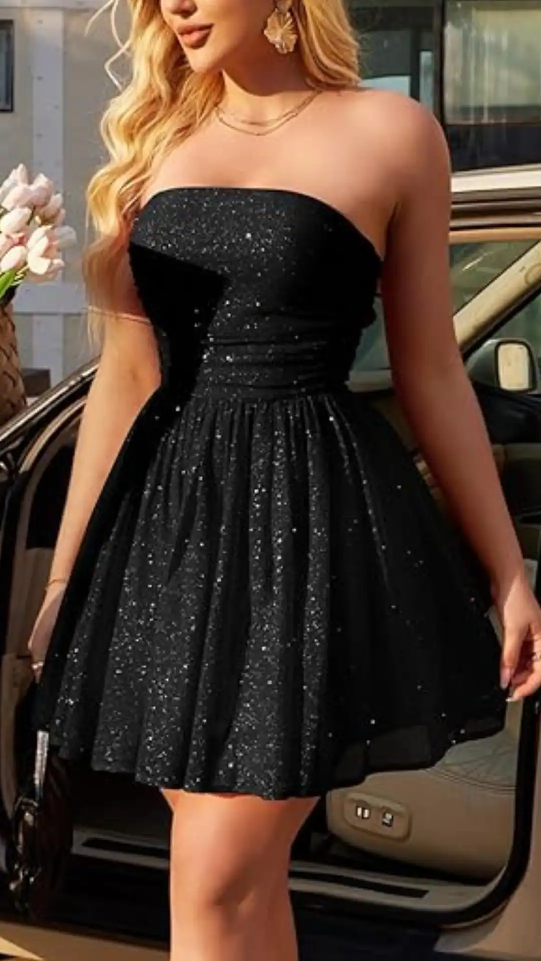 This black strapless homecoming dress features a fitted bodice with a textured, sparkling fabric that gives off a subtle shimmer, paired with a flared skirt that adds volume for a playful yet elegant look. The overall vibe is trendy and youthful, making it perfect for formal events like homecoming, catering specifically to teenage girls.