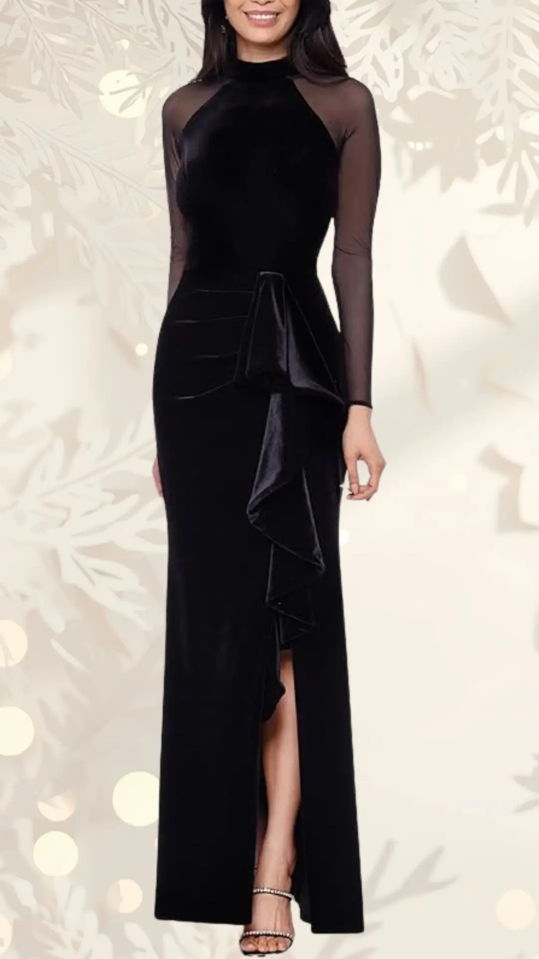 A fitted black velvet wedding guest dress features long sheer sleeves and a high neckline. It has an elegant draped ruffle detail on the side and a thigh-high slit, adding sophistication to the overall design. The background includes soft, glowing circular lights, creating a warm atmosphere.
