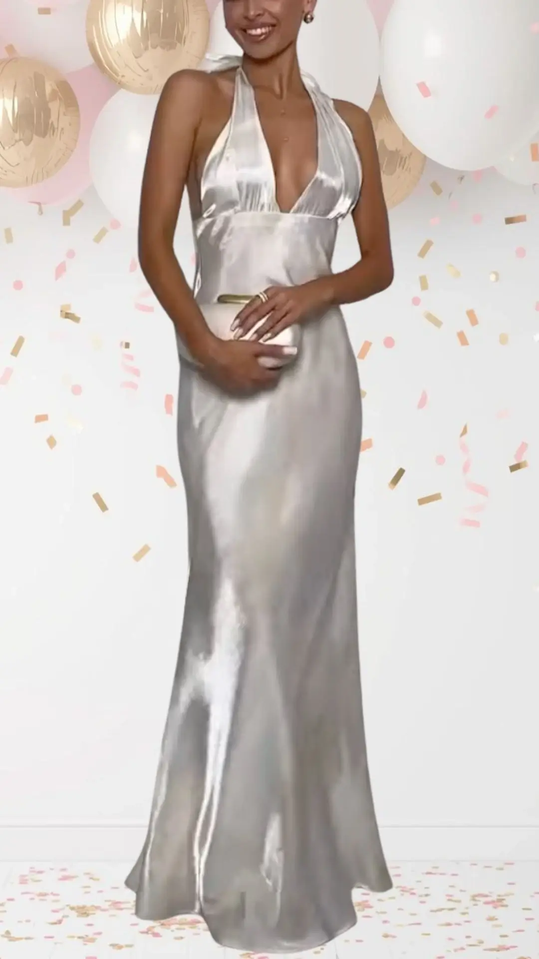 The bridal shower outfit features a shimmering silver dress crafted from a silky fabric that elegantly flows to the floor. It has a plunging halter neckline and open back, complemented by a fitted silhouette that accentuates the figure, creating a chic yet playful look appropriate for a celebratory occasion. Subtle details like a smooth finish enhance its elevated style, while the soft sheen adds a whimsical touch, making it perfect for a festive atmosphere.