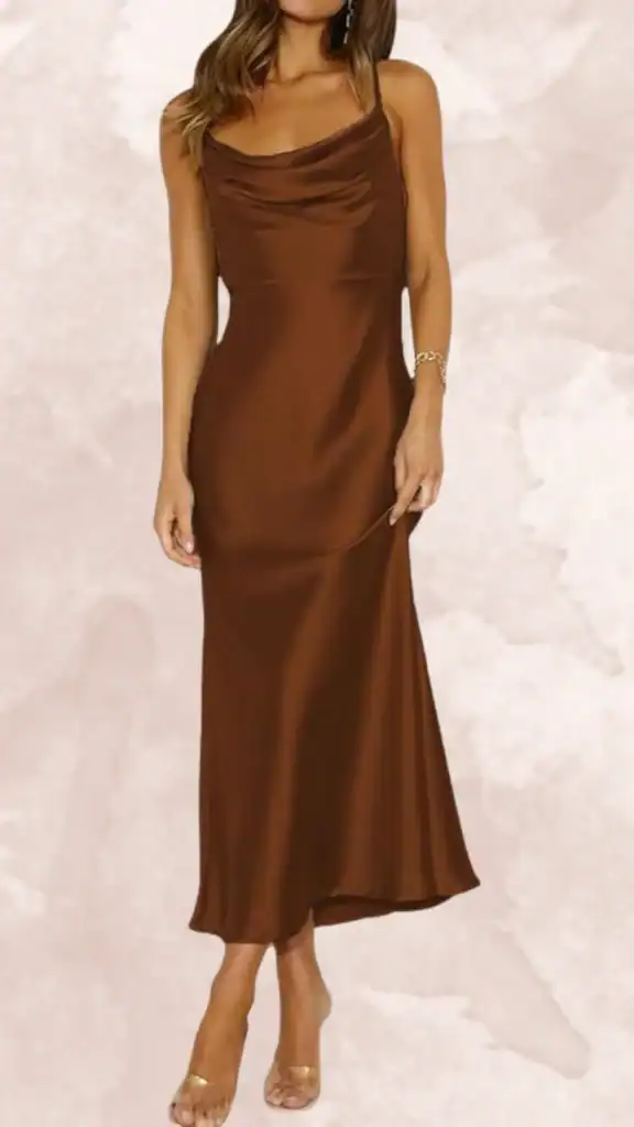 The dress features a rich, chocolate brown color with a smooth satin finish. It has a cowl neckline and thin spaghetti straps, with a form-fitting silhouette that extends to a midi length with a subtle, flowing hemline. This elegant design is perfect for bridesmaids, exuding sophistication and classic charm.