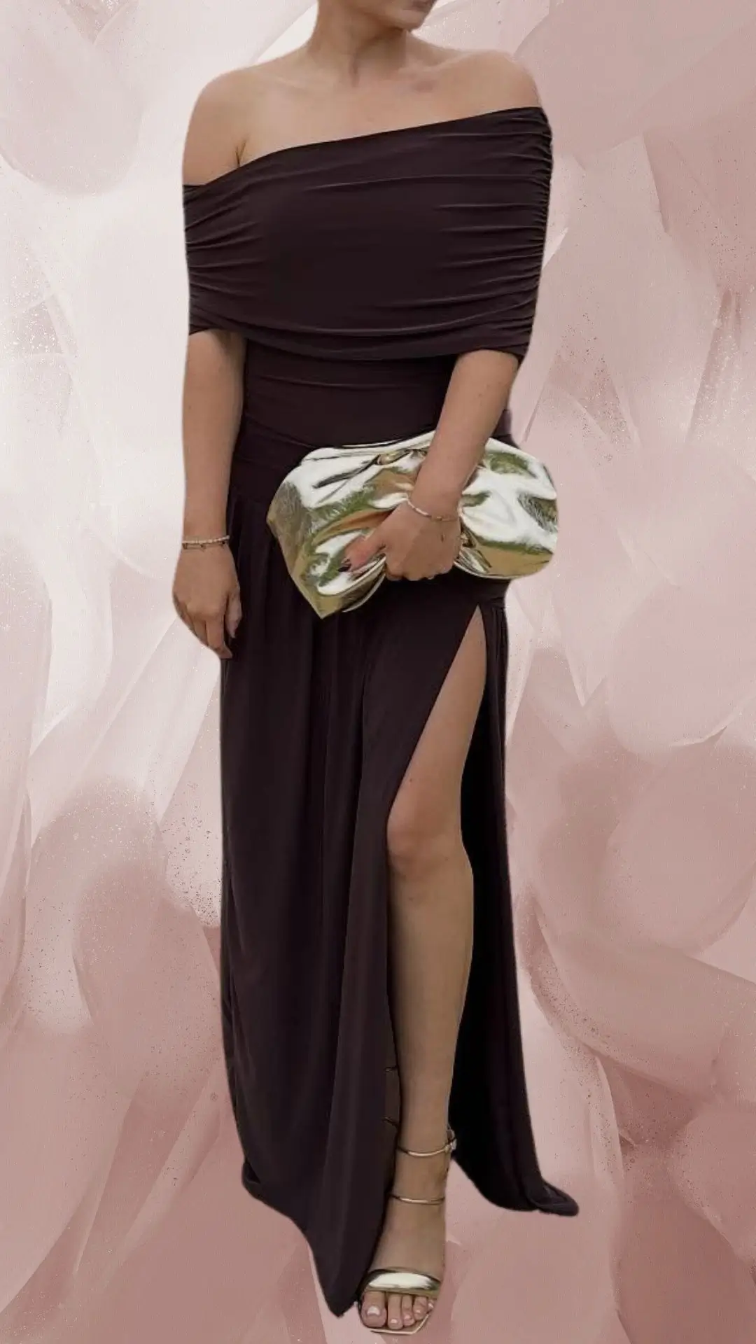 The outfit features a long, off-the-shoulder brown dress made from a draping, soft fabric that highlights the silhouette and includes a high slit for elegance. The dress has a smooth finish, with subtle ruching around the bodice, and is paired with delicate, strappy gold heels. Accessorized with a shiny, metallic clutch, this ensemble exudes sophistication and grace.
