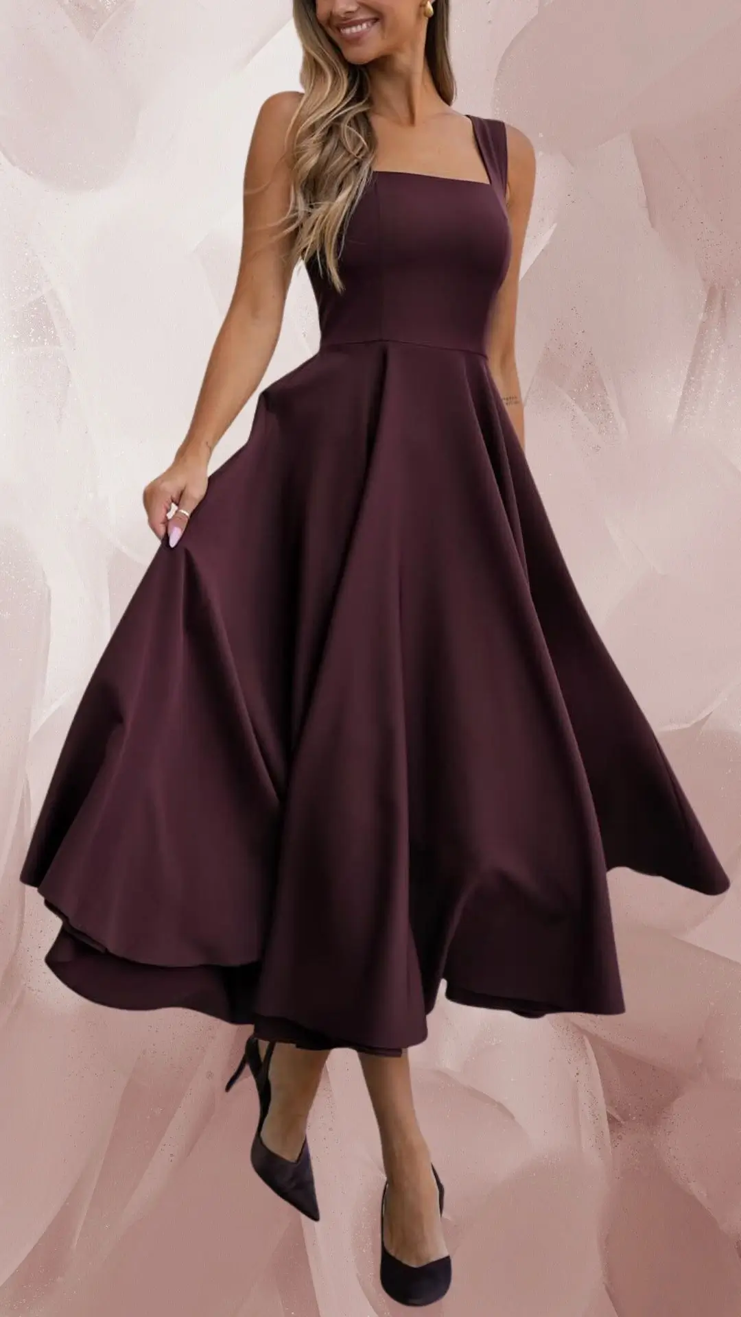 A long, flowing brown dress features a fitted bodice with a square neckline and wide straps, crafted from a smooth and soft fabric that drapes elegantly. The dress flares out from the waist, creating a flattering silhouette, complemented by classic black high-heeled pumps. This outfit exudes sophistication with its rich color and timeless design.