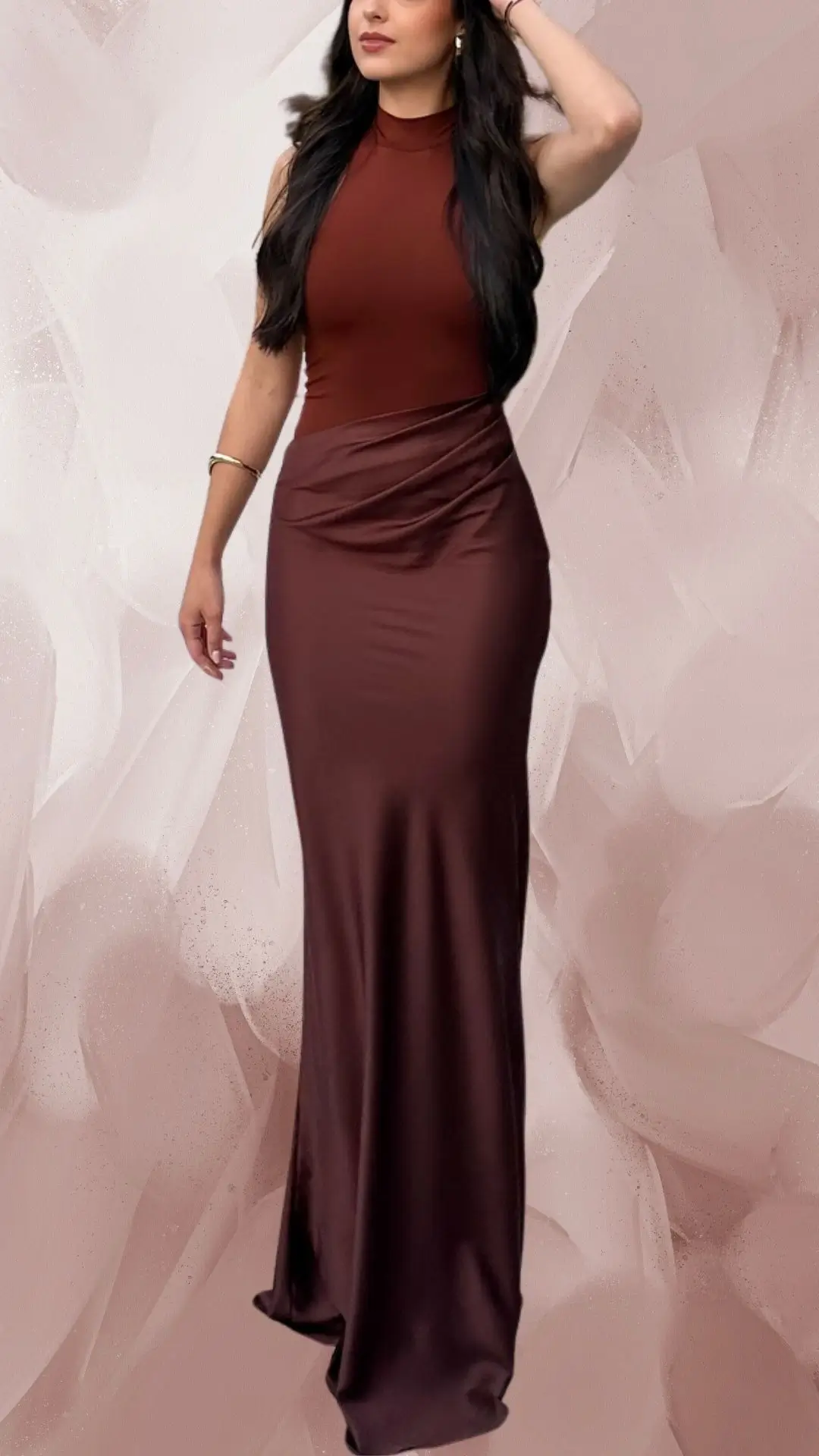 The outfit features a long, form-fitting brown dress made of a smooth, satin-like fabric that drapes elegantly to the floor. It has a sleek, high neckline and short cap sleeves, accentuating a modern silhouette, while the dress incorporates a stylish twist at the waist for added dimension. Paired with matching brown heels, this ensemble exudes sophistication and poise.