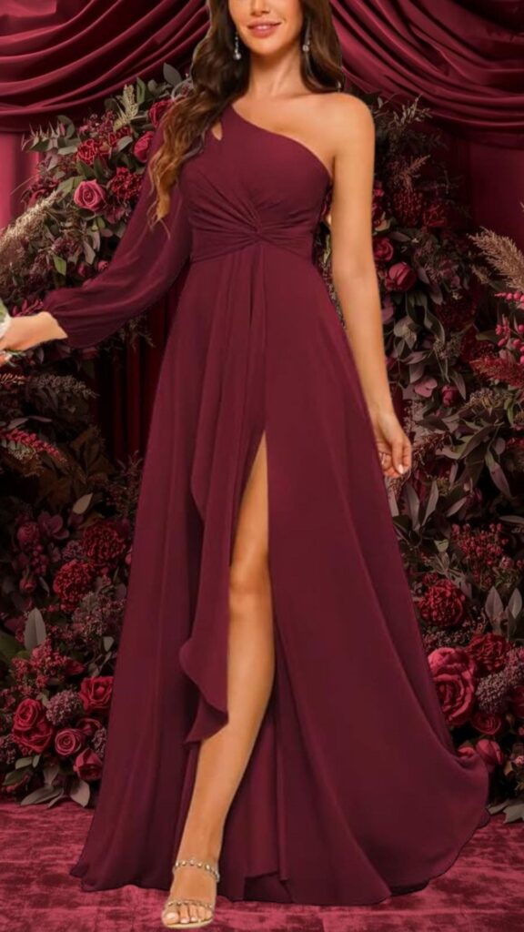 This elegant burgundy bridesmaid dress features a one-shoulder neckline and a long, flowing sleeve on one side. The gown is crafted from a soft, textured fabric with a flattering drape, showcasing a thigh-high slit and intricate twist detailing at the waist for a chic silhouette.