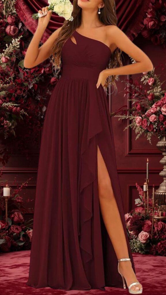 This burgundy bridesmaid dress features a one-shoulder neckline with a subtle cutout, enhancing its elegant silhouette. The gown is made of flowing fabric with a thigh-high slit and soft ruffles cascading down the side, creating a romantic look ideal for a wedding. The rich color and design elements add sophistication, making it a beautiful choice for bridesmaids.