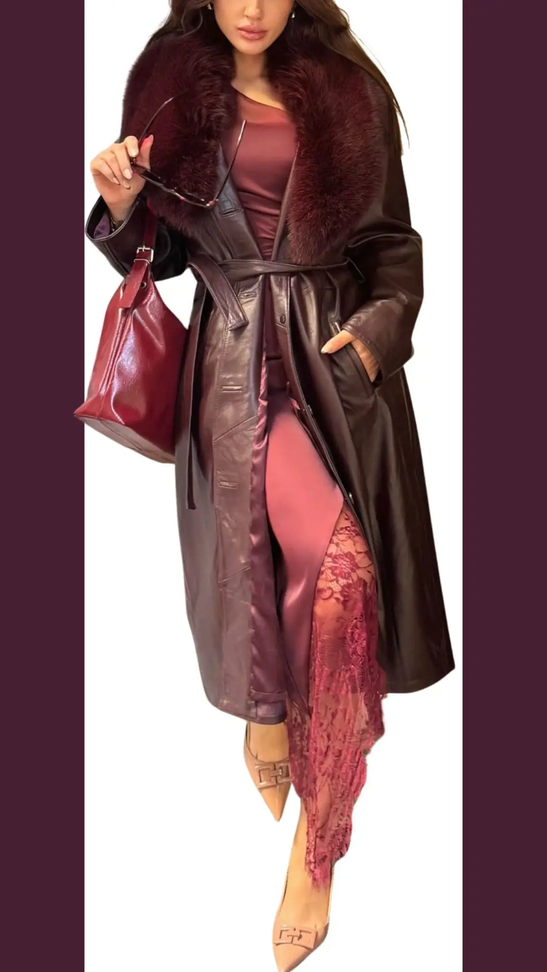 The outfit features a long, burgundy leather coat with a plush faux fur collar, detailed with a waist tie and side pockets. Underneath, a streamlined burgundy dress with a side slit showcases delicate lace trim, while the look is completed with sleek, pointed-toe beige heels adorned with a subtle buckle. A matching burgundy handbag adds a cohesive touch to this elegant ensemble.