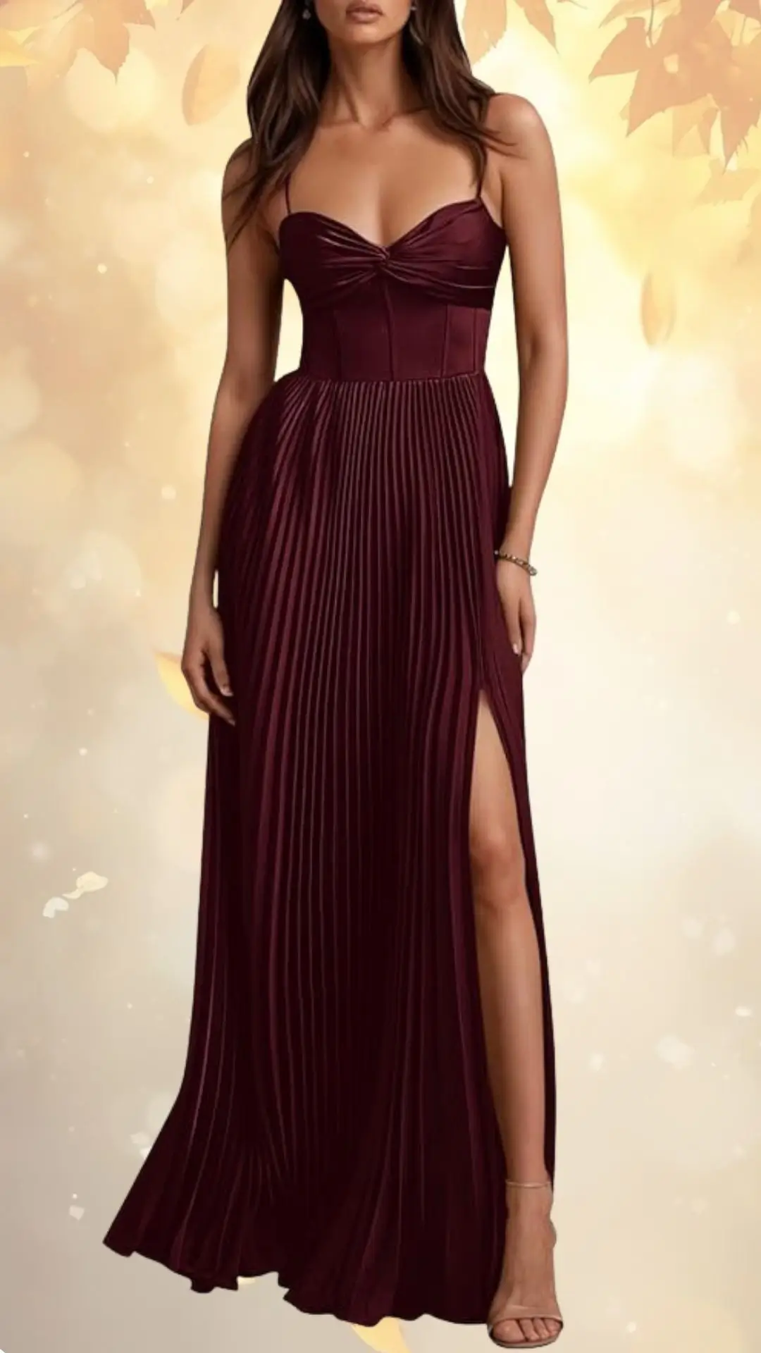 A rich burgundy wedding guest dress features a fitted bodice with a sweetheart neckline and pleated skirt. The skirt has a daring thigh-high slit, creating an elegant yet modern silhouette. The model wears minimal accessories and strappy heels, enhancing the dress's sophisticated look.