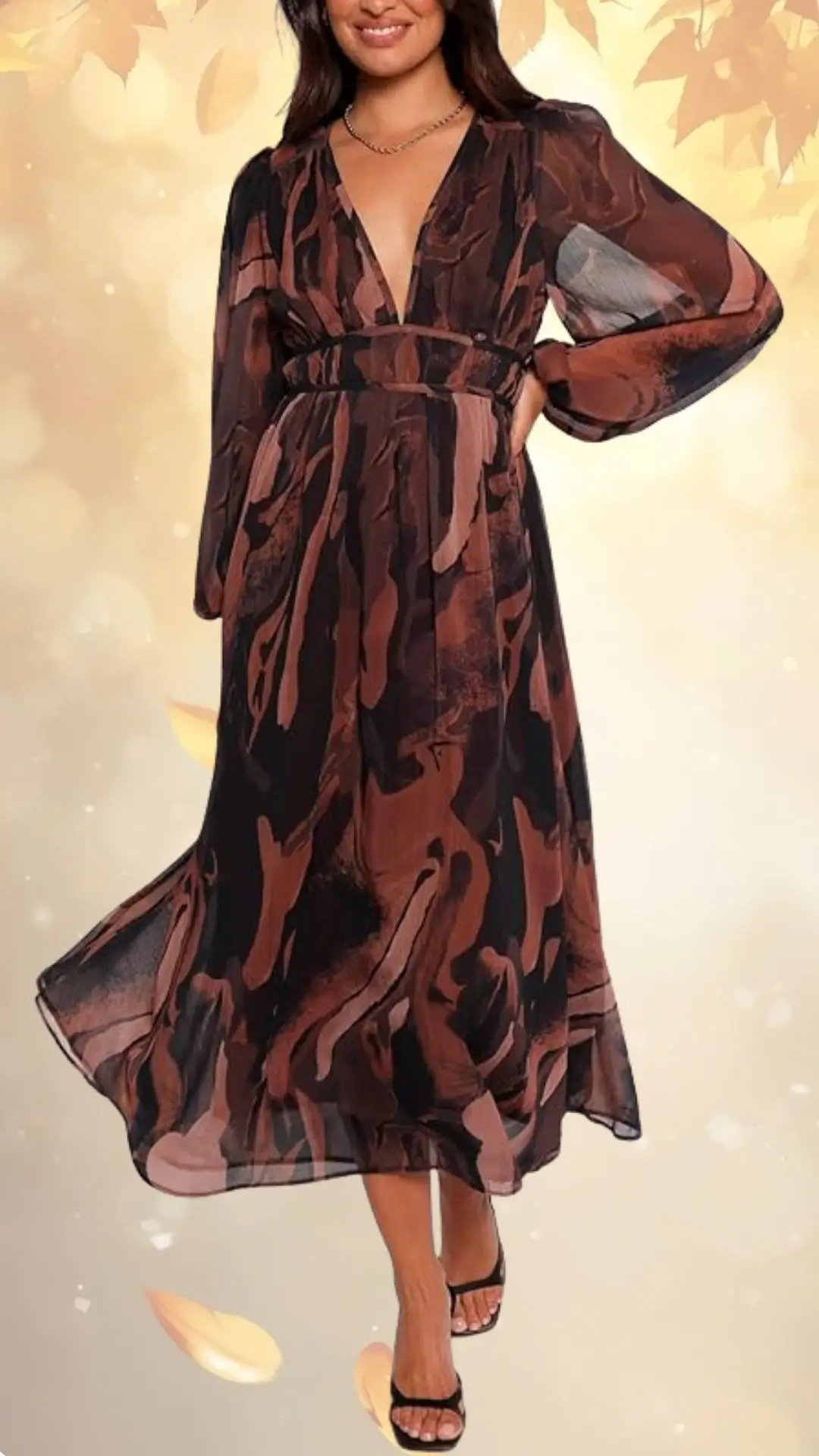 A flowing wedding guest dress features rich burgundy and warm earth tones in a fluid, abstract pattern. The dress has long, semi-sheer sleeves and a deep V-neckline, cinched at the waist for a flattering silhouette that reaches mid-calf. The lightweight fabric drapes elegantly, perfect for fall celebrations.