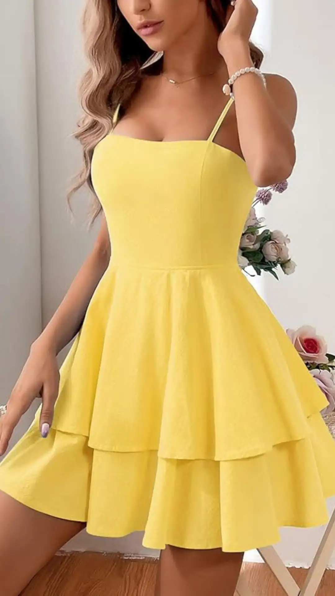 This playful homecoming dress features a vibrant canary yellow hue with a textured finish, designed in a fit-and-flare silhouette. It has delicate spaghetti straps and a tiered, voluminous skirt that evokes a youthful and cheerful vibe, making it perfect for a school dance or party setting.