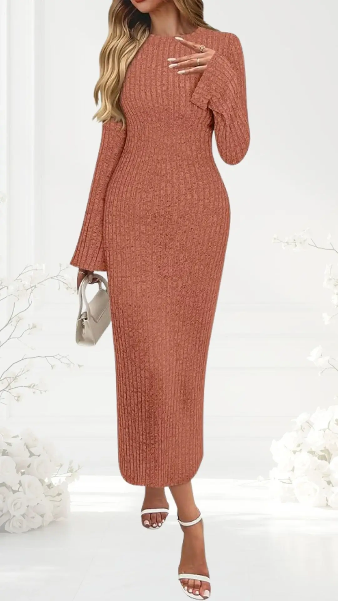 A form-fitting, rust-colored ribbed dress with long, flared sleeves and a modest crew neckline cascades to mid-calf. The figure-hugging design emphasizes the waist and is paired with strappy white heels. The background features a soft, neutral setting with delicate floral accents.