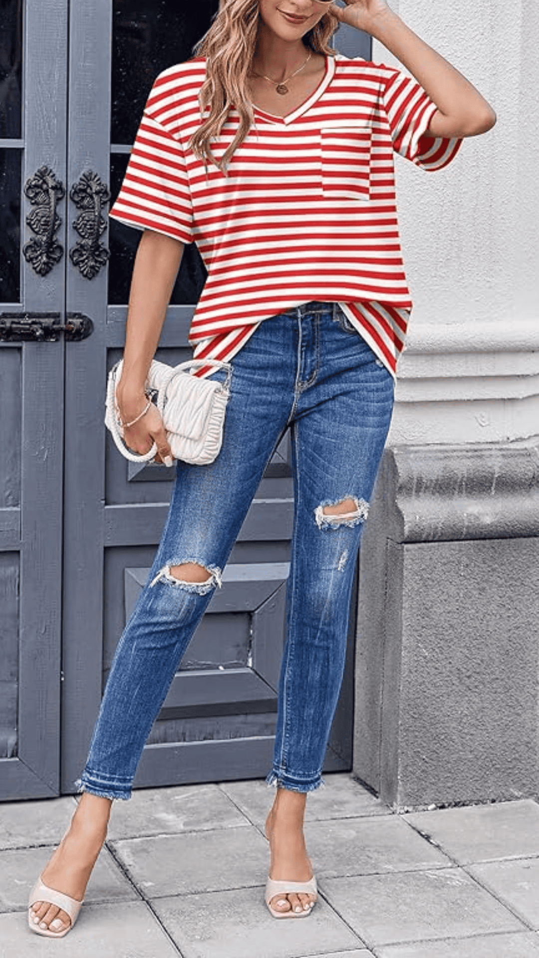 This chic outfit features a relaxed red and white striped V-neck top crafted from a soft, lightweight fabric, paired with distressed blue jeans that add a casual edge. The overall vibe is playful yet sophisticated, making it perfect for a casual Fourth of July outing or summer gathering.