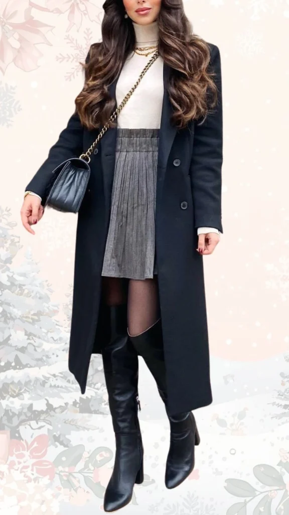 A stylish winter outfit featuring a long black coat layered over a cream turtleneck sweater paired with a pleated gray skirt. The look is completed with knee-high black leather heeled boots, a black handbag with a chain strap, and delicate gold accessories for an elevated touch. The combination of textures and colors creates a chic and put-together appearance perfect for colder weather.