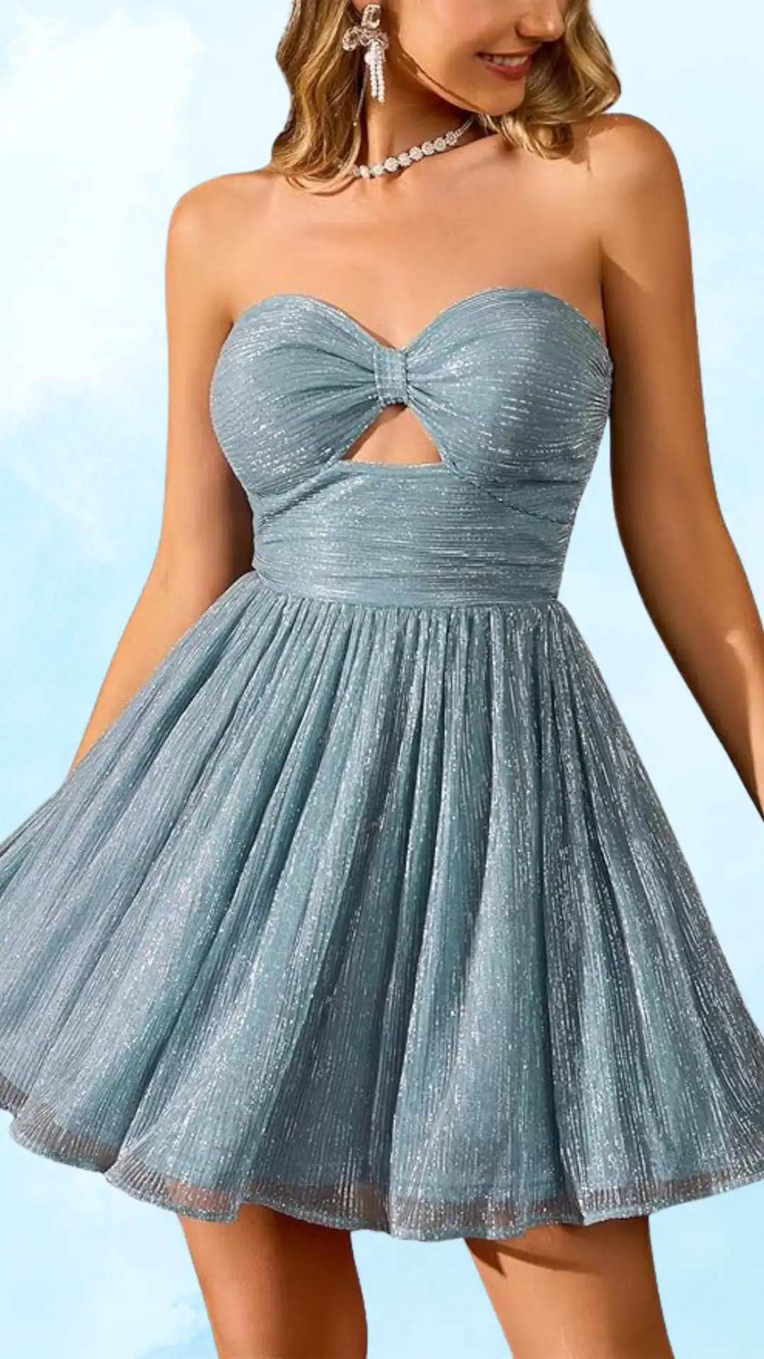 This stylish homecoming dress features a sparkling dusty blue fabric with a soft, shimmery texture and a fitted, strapless bodice that showcases a unique keyhole detail at the center, transitioning into a flared, voluminous skirt. The overall vibe is youthful and trendy, making it perfect for a homecoming or school dance, designed for teenage girls who want to feel both elegant and fun.
