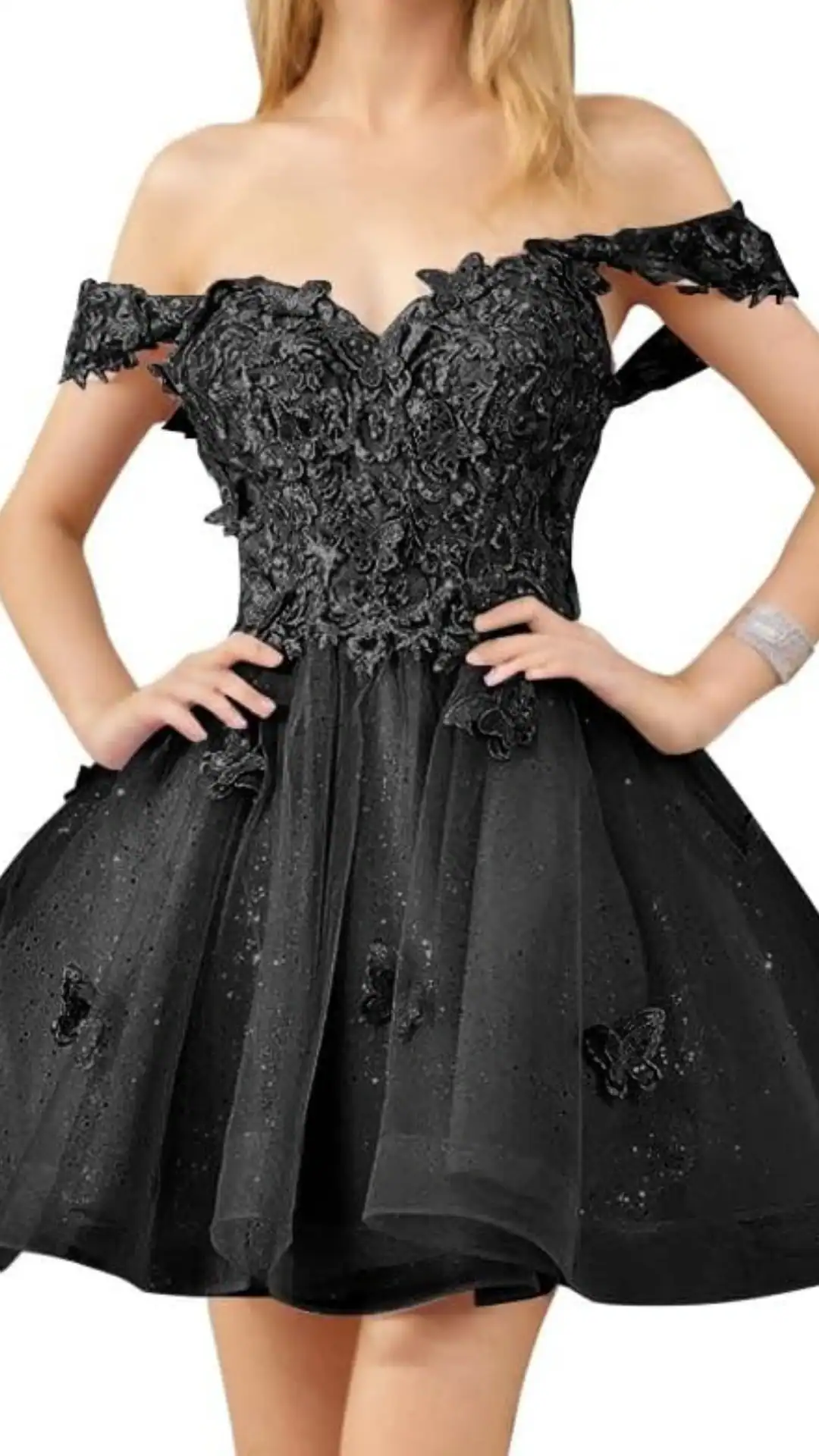 This elegant black homecoming dress features a fitted, off-the-shoulder bodice adorned with intricate floral lace details, transitioning into a voluminous, layered tulle skirt that creates a playful silhouette. The overall vibe is romantic and trendy, making it perfect for a formal event or school dance for teenage girls.