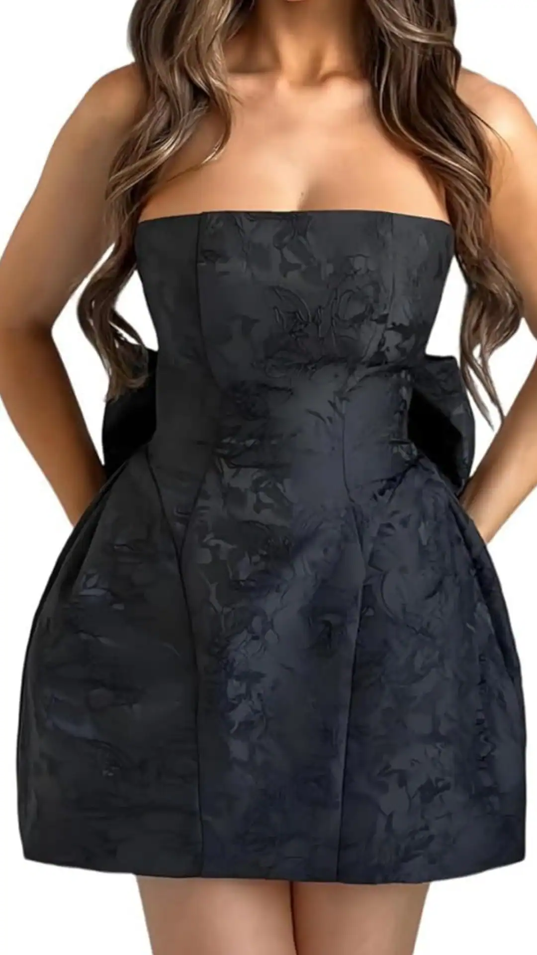 This elegant strapless black homecoming dress features a structured corset-style bodice with a subtly textured floral pattern, adding depth to the rich fabric. Its fit is cinched at the waist, leading into a voluminous skirt that offers a playful yet sophisticated vibe, perfect for a teen attending a party or school dance.