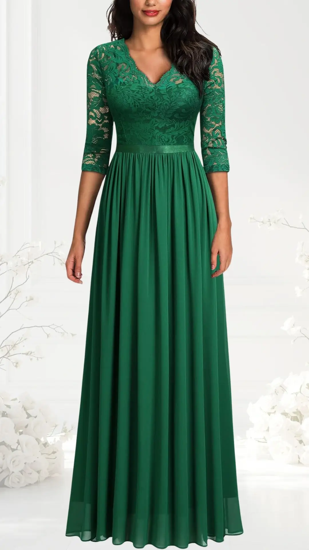 Emerald green wedding guest dress featuring a structured bodice with a V-neckline and three-quarter lace sleeves. The flowing skirt cascades elegantly to the floor, enhancing the dress's graceful silhouette. Delicate floral lace details adorn the upper section, adding texture and visual interest.