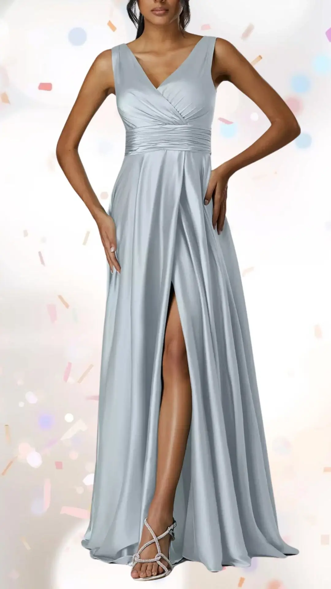 The dress features a soft, flowing silhouette in a light blue satin fabric, with a twist-front bodice that creates an elegant V-neckline and wide, supportive shoulders. A high slit adds a touch of whimsy, while the pleated detailing at the waist enhances both comfort and style, making it suitable for a celebratory engagement party without being overly formal. The overall design balances sophistication and playfulness, complemented by strappy, embellished sandals.