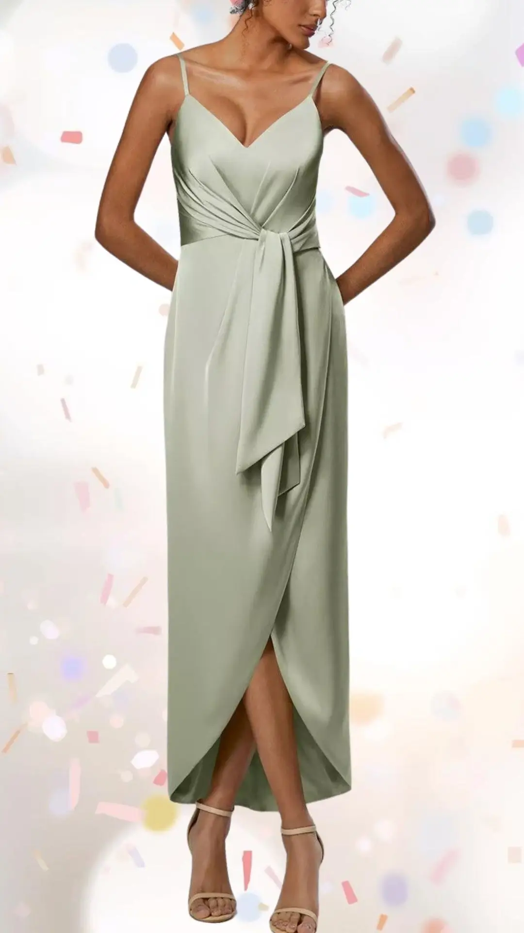 This elegant engagement party dress features a soft sage green hue and is crafted from a smooth, flowing fabric that enhances its graceful silhouette. It has a fitted bodice with delicate spaghetti straps and a flattering V-neckline, while a knotted detail at the waist adds a touch of sophistication. The dress is designed with a high-low hem, creating a playful yet refined look, perfect for celebratory occasions.