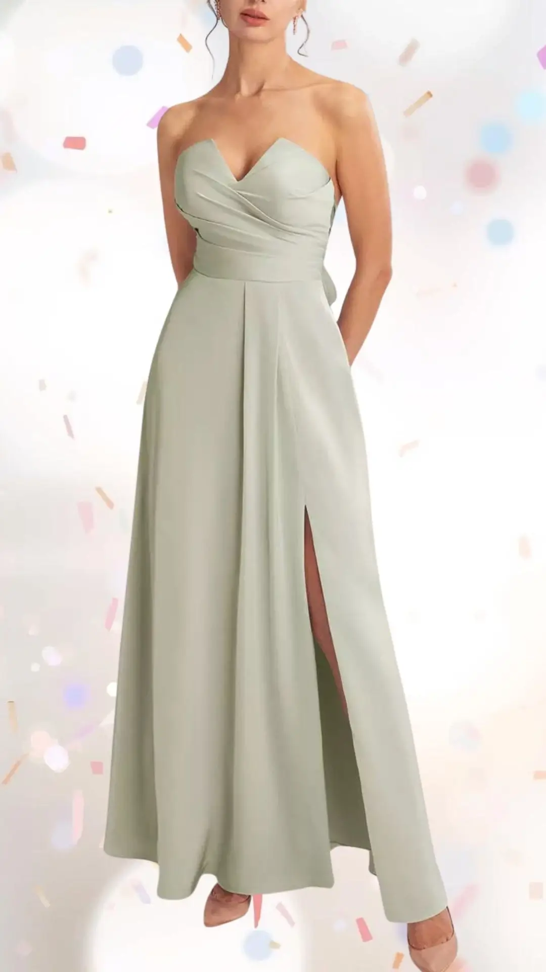 The dress features a strapless sweetheart neckline with soft pleats, crafted from a lightweight, flowing fabric in a gentle sage green hue. It incorporates a side slit for a playful touch, balancing elegance and fun, while its long, relaxed silhouette enhances movement for a celebratory atmosphere. The design is complemented by a fitted bodice that gracefully transitions into an A-line skirt, making it perfect for an engagement party.