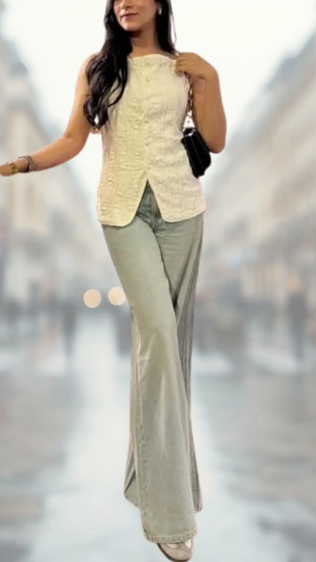 The outfit features a fitted, sleeveless, light-colored top made of textured fabric, paired with high-waisted, wide-flare jeans in a soft, muted shade. The look is completed with stylish, strappy heels that add elegance, while a small black handbag enhances the chic aesthetic.