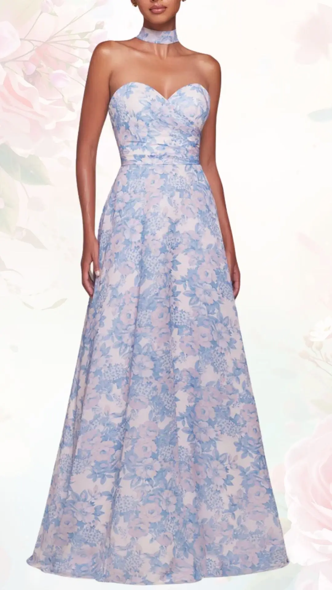 A strapless floral dress features a sweetheart neckline and a fitted bodice, adorned with a blue and pink floral pattern. The gown flows into a full skirt, creating an elegant silhouette, complemented by a matching choker. The soft fabric enhances the light and airy feel, perfect for a spring wedding.