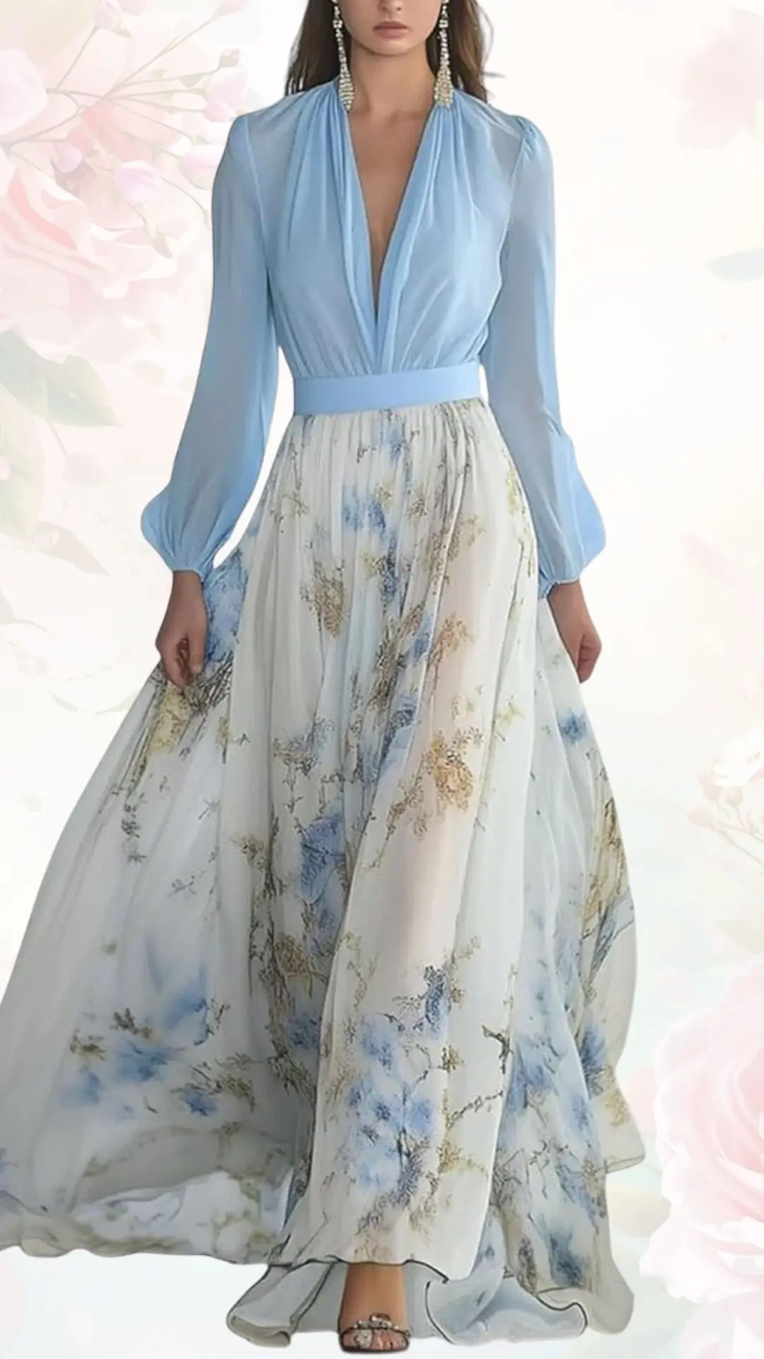 The dress features a light blue, deep V-neckline bodice with long, flowing sleeves and a wide waistband, paired with a long skirt adorned with delicate floral patterns in soft blue and gold hues. The fabric appears airy and lightweight, creating an elegant silhouette ideal for a spring wedding. Subtle shimmer from the decorative elements enhances its charming and romantic aesthetic.