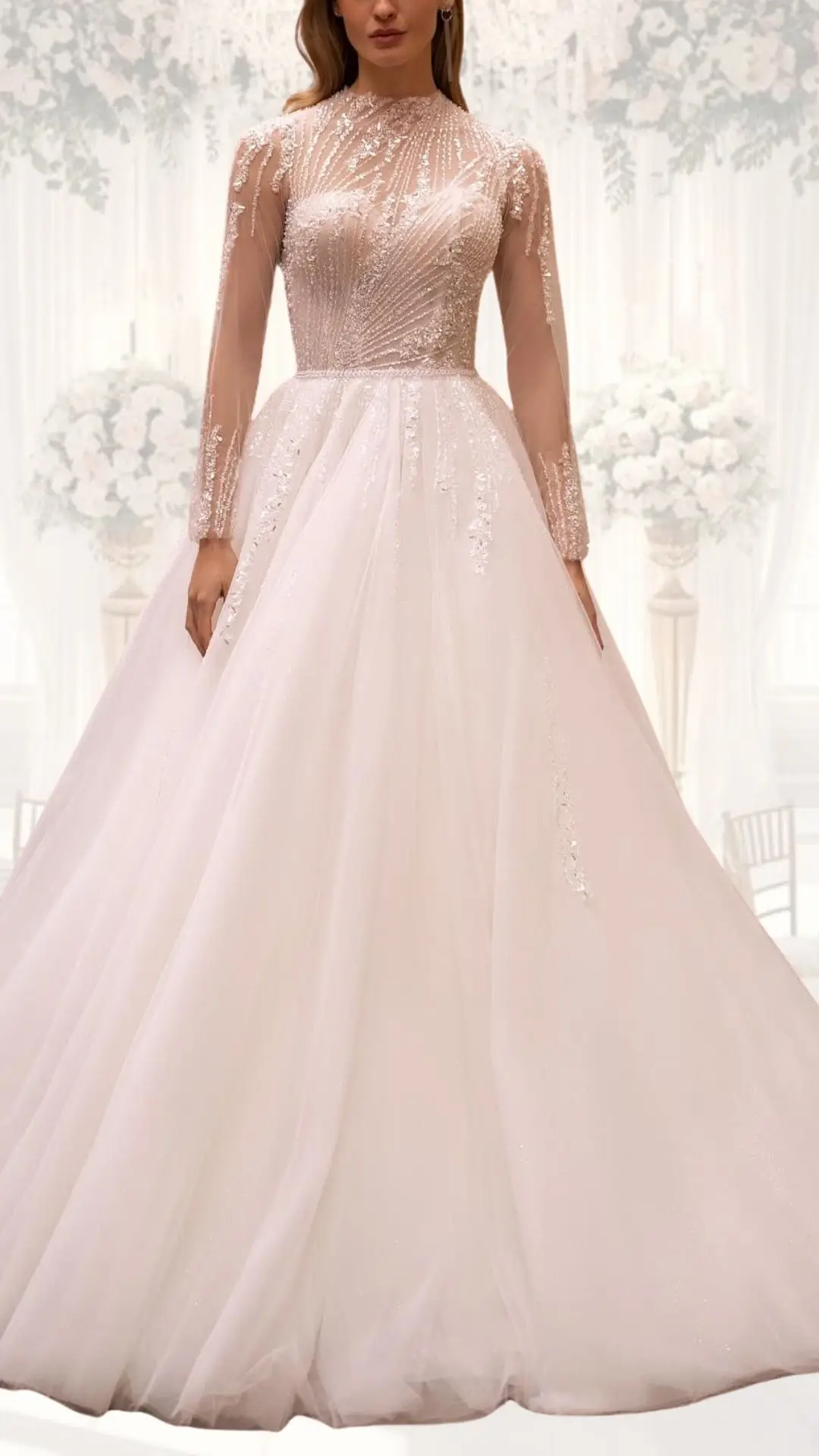 This high neck wedding gown features a fitted, beaded bodice in soft blush tones, complemented by long, sheer sleeves adorned with intricate embellishments. The flowing A-line skirt, made of delicate tulle, creates an elegant silhouette that is ideal for a winter wedding, exuding a classy and vintage appeal. The overall design showcases modesty while incorporating luxurious textures and intricate detailing.
