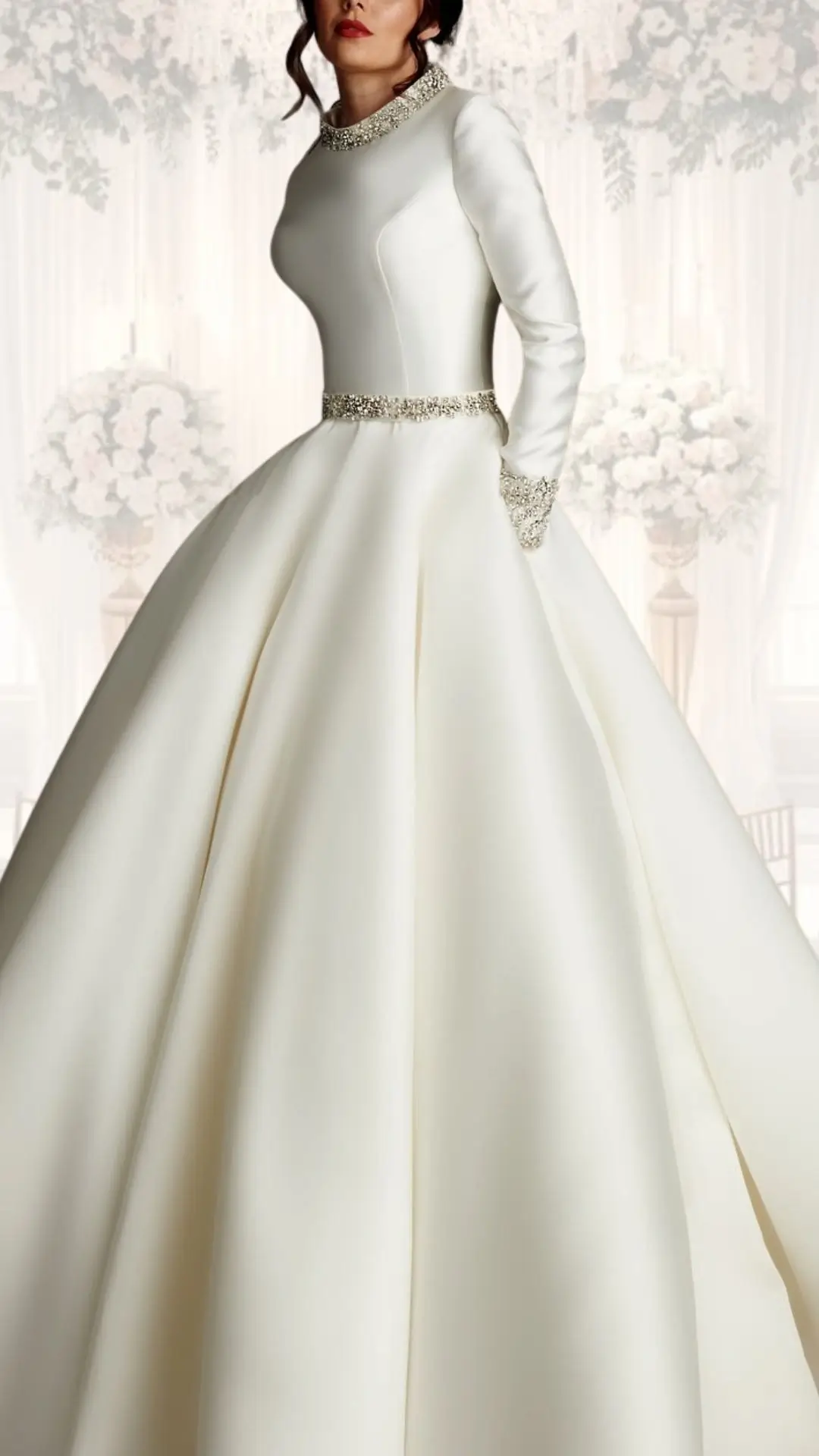 This elegant high neck wedding dress features long, fitted sleeves and is crafted from luxurious silk-like fabric, exuding a vintage allure. The gown is adorned with a delicate jeweled neckline and a matching belt, highlighting the structured bodice, while the voluminous skirt flows gracefully, making it an exquisite choice for a winter wedding or a classy, modest look. The soft, creamy white shade enhances its timeless appeal.