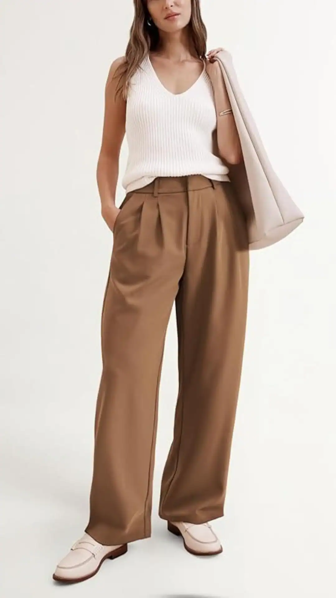 This outfit features high-waisted, wide-leg pants in a warm, earthy brown, crafted from a smooth, lightweight fabric that drapes elegantly. Paired with a fitted, ribbed white tank top, the look exudes a polished yet relaxed vibe, ideal for casual outings or smart-casual events.