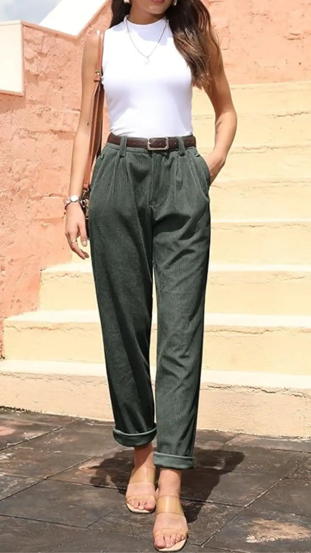 The outfit features high-waisted, tailored green trousers with a relaxed fit and rolled cuffs, made from a textured cotton blend for breathability. Paired with a fitted white sleeveless top, it exudes a chic, casual vibe suitable for daily outings or brunch events.