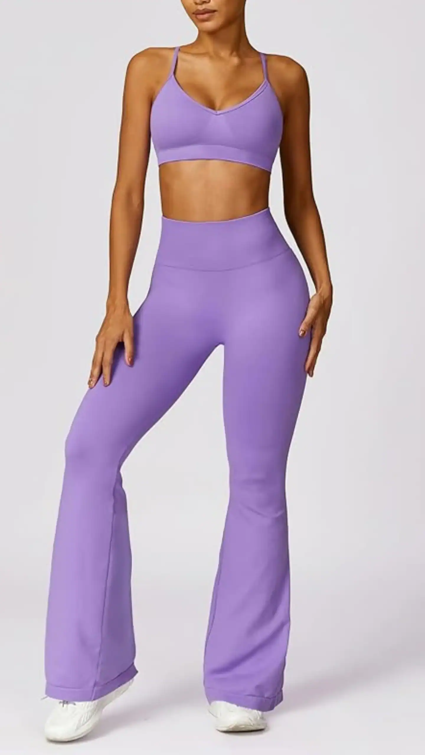A sleek, high-waisted sports set in a vibrant lavender hue, featuring a soft, four-way stretch fabric blend for optimal comfort and moisture-wicking capabilities. The sporty V-neck bra has adjustable straps and removable pads, while the flared pants are designed with a ruched back for enhancing curves, making it ideal for both workouts and casual outings.