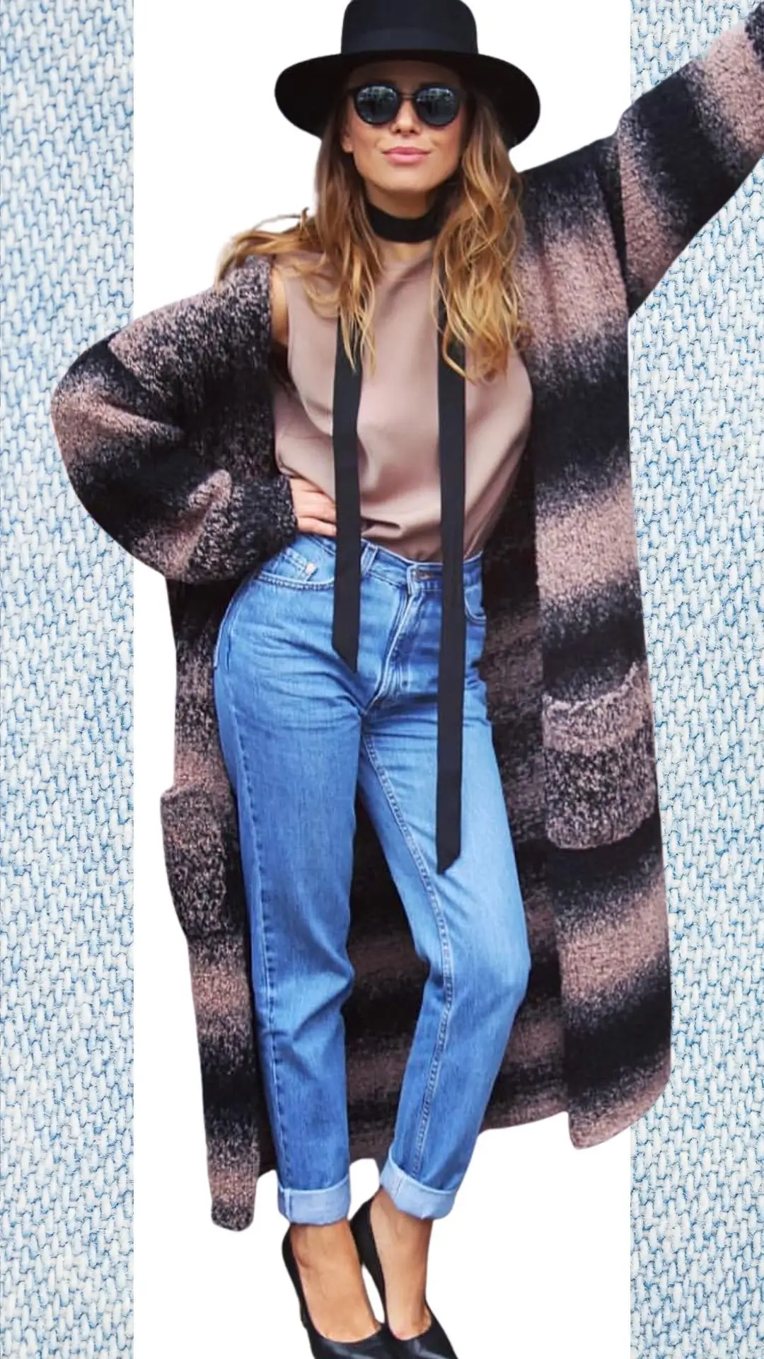 The outfit features light blue high-waisted jeans made from soft denim, complemented by a silky taupe top with a sleek black ribbon detail. Layered over is a cozy, oversized knit cardigan in warm earth tones, and the look is accessorized with a wide-brimmed black hat and chic black heeled shoes, perfect for transitional weather from winter to spring.