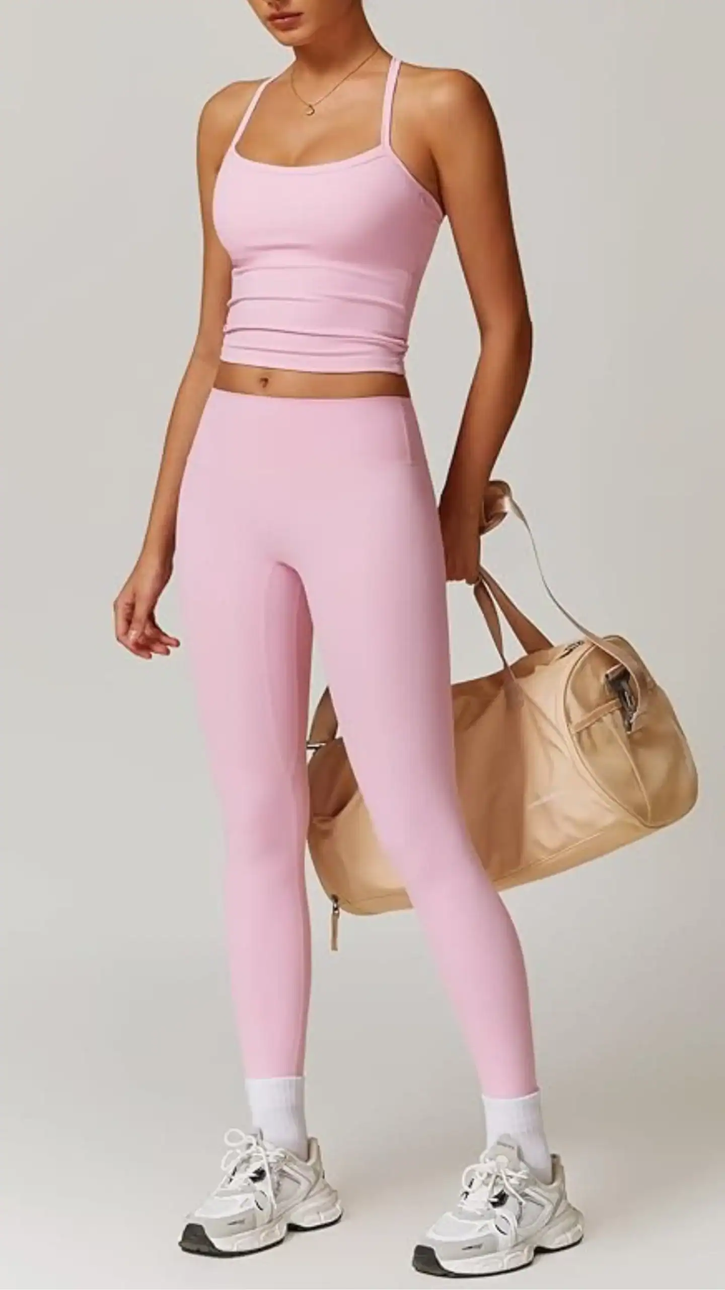 Two-piece athletic outfit featuring a soft, breathable, light pink seamless tank top and matching high-rise leggings, made from 78% Polyamide and 22% Elastane for a stretchy fit, enhanced with scrunch details for a flattering silhouette. Perfect for various workouts and casual outings, this set embodies a sporty and vibrant vibe, balancing functionality and style for active lifestyles.