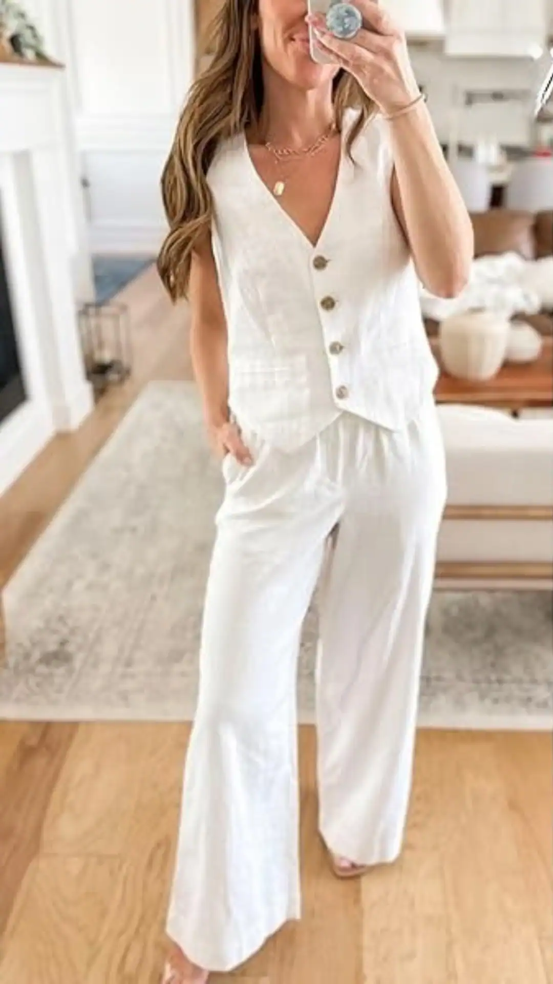This linen matching set features a sleeveless, button-down vest with a relaxed fit, paired with wide-leg pants that offer ease and comfort. In a crisp white hue, the outfit exudes a minimalist and fresh vibe, making it ideal for casual outings or warm-weather events.