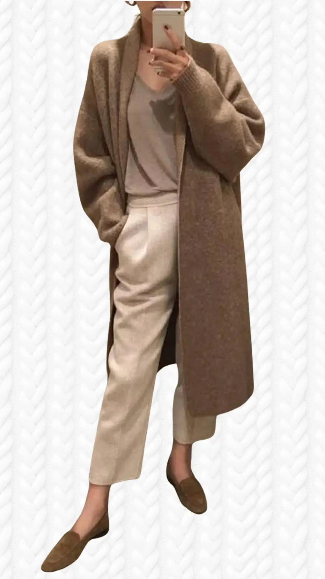 A long, brown cardigan features a cozy, textured knit design with oversized sleeves and an open front. It is paired with a light beige top and matching tailored pants, creating a harmonious color palette, complemented by brown loafers for a polished yet comfortable look. The outfit exudes elegance and warmth, perfect for a casual day out.