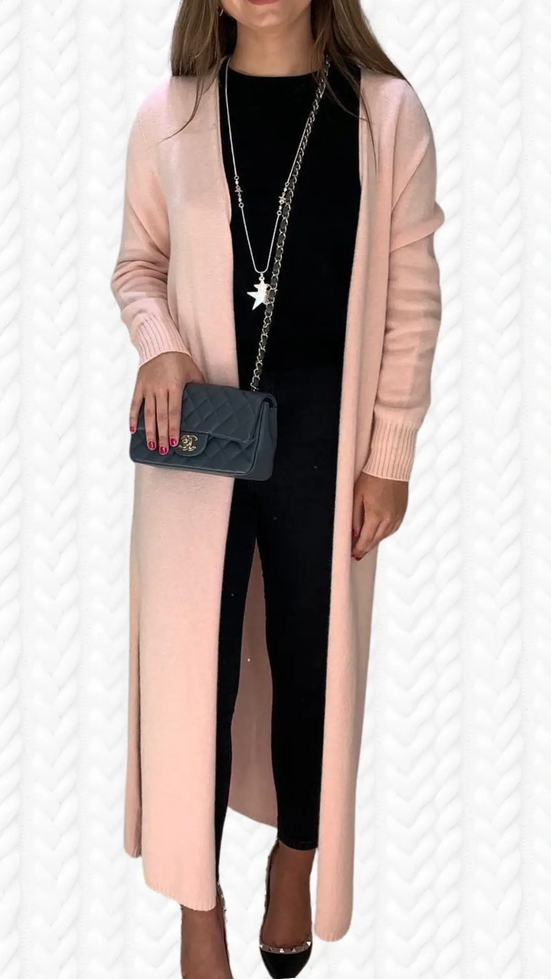 The outfit features a long, soft pink cardigan made from a lightweight, textured knit fabric, with ribbed cuffs and an open front, layered over a black top. It is paired with fitted black leggings and stylish black heels adorned with studded accents. The look is completed with a quilted black crossbody bag, adding a touch of elegance.