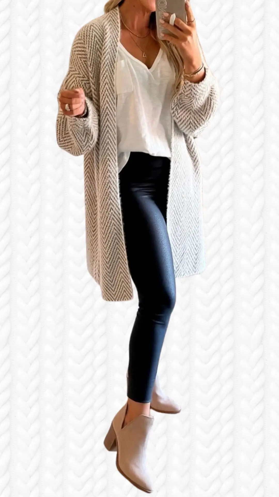 The outfit features a long, open-front cardigan with a soft, knit texture in a neutral cream color with a subtle herringbone pattern. Underneath, it is complemented by a loose-fitting white top with a v-neckline, paired with sleek black leggings that offer a contrasting sheen. Footwear consists of stylish taupe ankle boots with a block heel, enhancing the overall chic and cozy aesthetic.