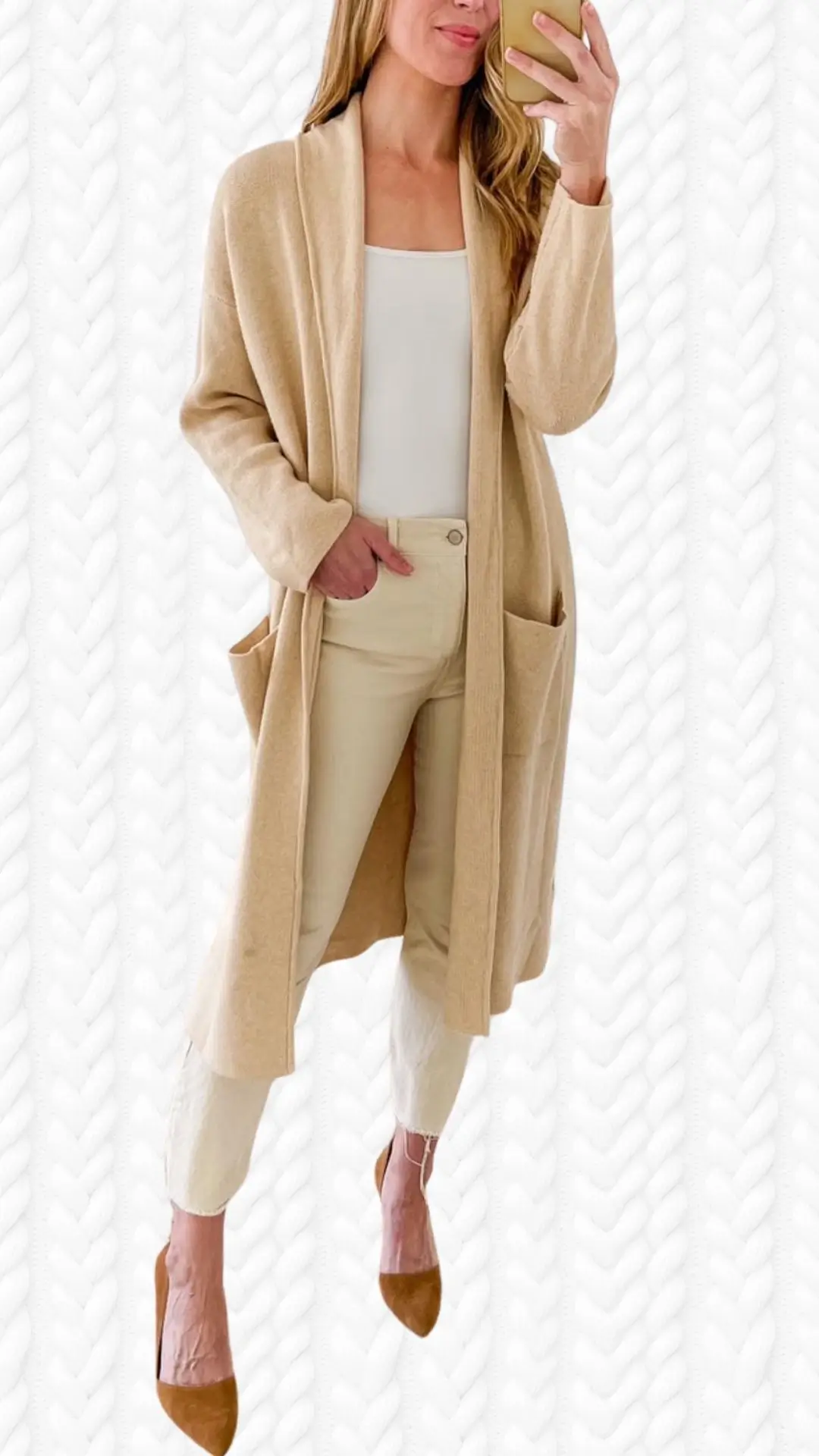 A cozy, long beige cardigan features a relaxed fit, open front, and two front pockets, paired with a fitted white tank top and light beige pants. The outfit is completed with stylish, pointed-toe brown heels that add a chic touch. The soft fabric of the cardigan contrasts beautifully with the smooth textures of the top and pants, creating an elegant yet comfortable look.