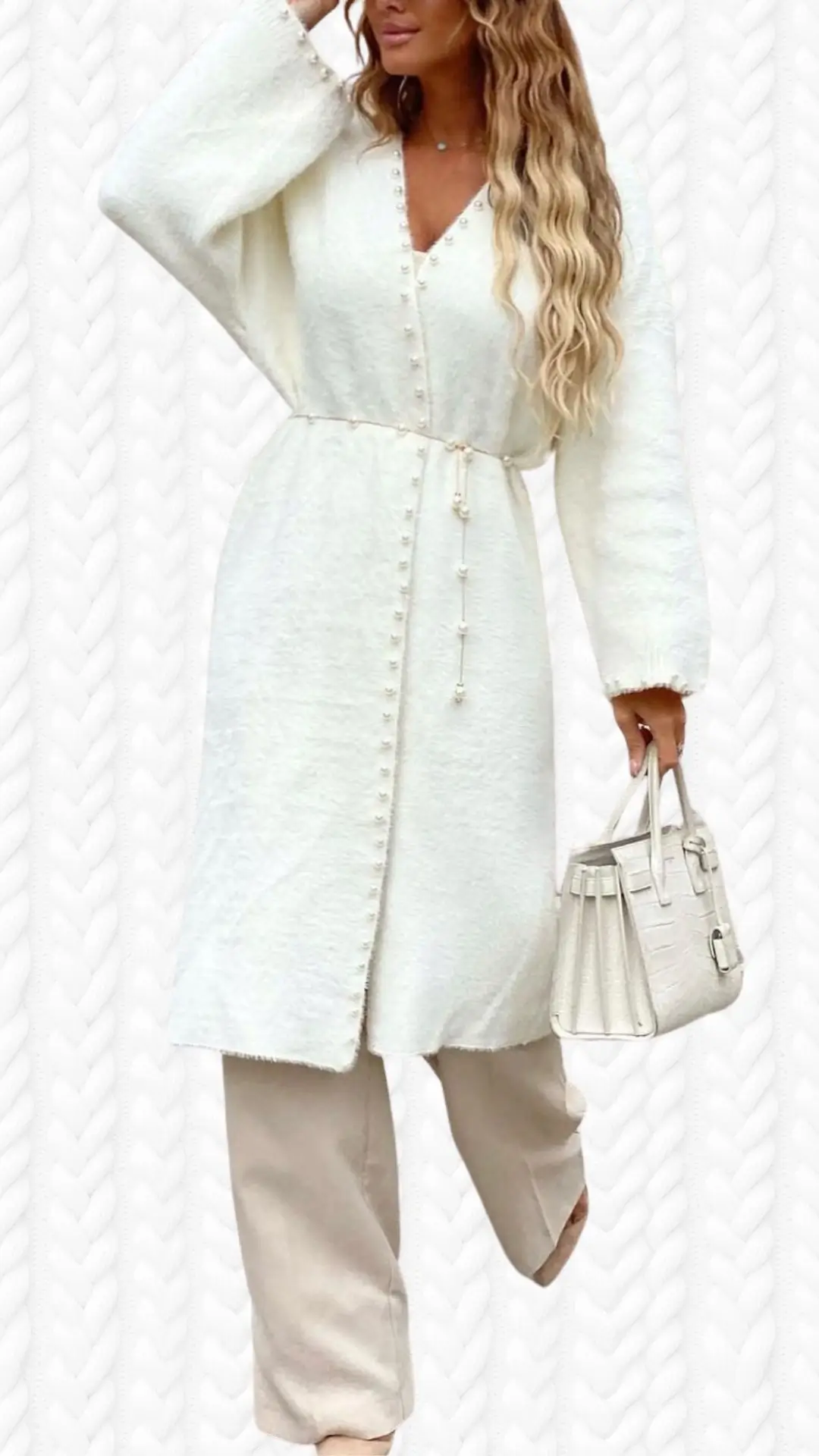 A soft, off-white long cardigan features a relaxed fit, deep V-neckline, and voluminous sleeves with delicate button details along the front. The fabric has a cozy texture, and the outfit is complemented by beige, loose-fitting trousers and chic light-colored shoes, along with a stylish handbag. The cardigan is cinched at the waist by a thin belt, enhancing its elegant silhouette.
